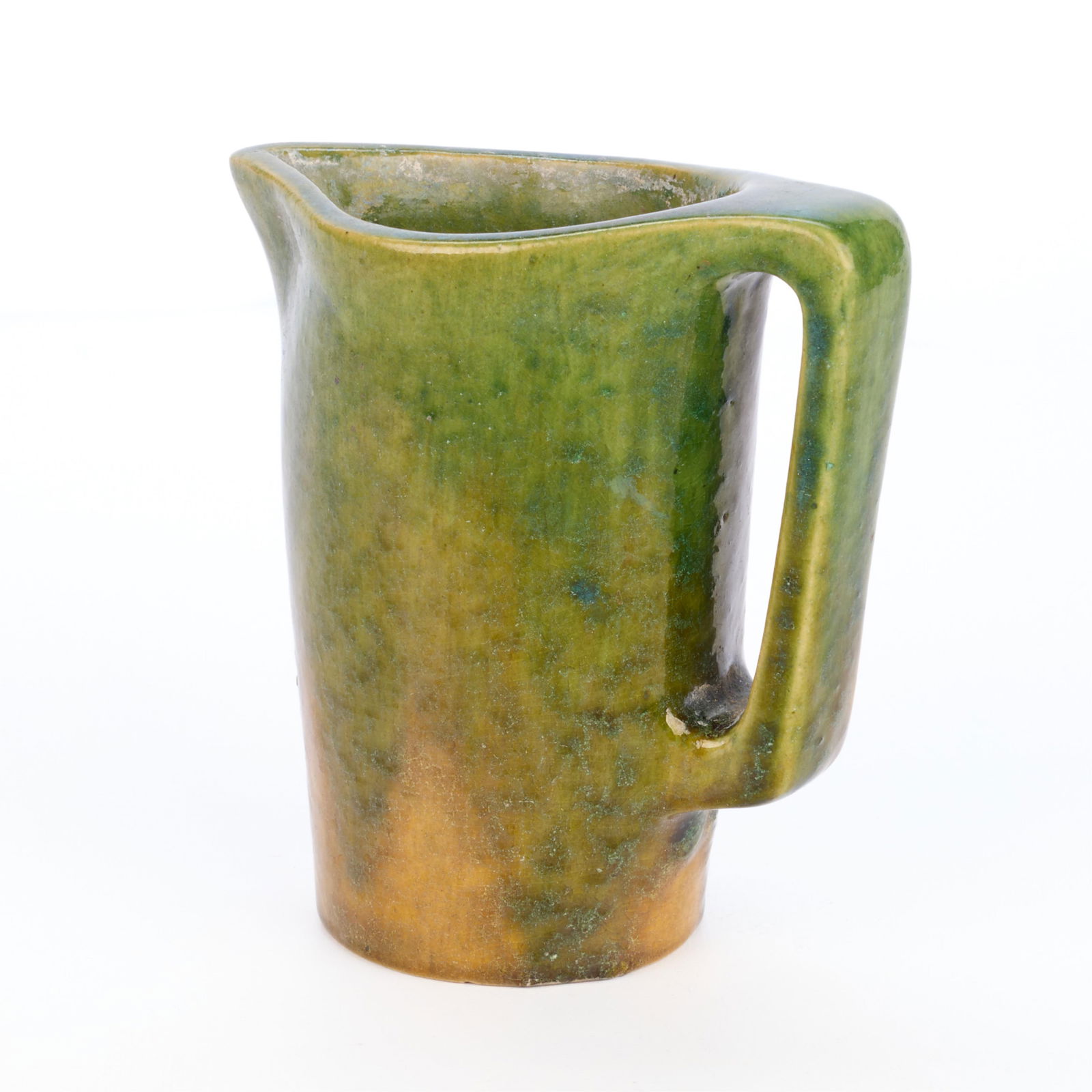 Arts & Crafts Ceramic Olive Green Pitcher: Arts & Crafts pottery pitcher with an applied loop handle. Executed in a glossy olive green glaze.Height: 5 1/2 in x width: 5 in x diameter: 3 in.