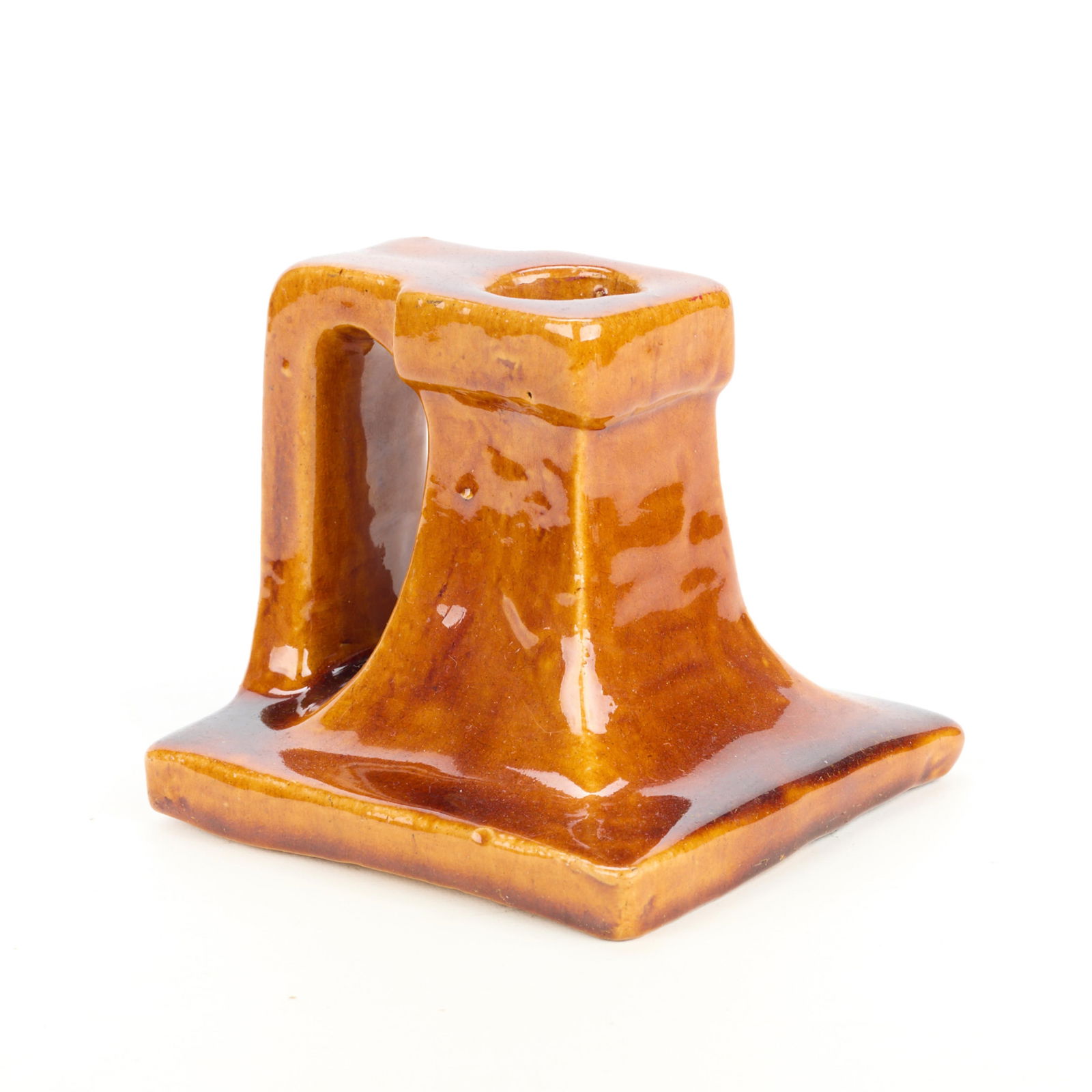 Arts & Crafts Glossy Orange Pottery Candlestick: Arts & Crafts ceramic candlestick, candle holder, or chamber stick. Executed in a glossy orange glaze.Height: 3 3/4 in x width: 4 in x depth: 3 3/4 in.