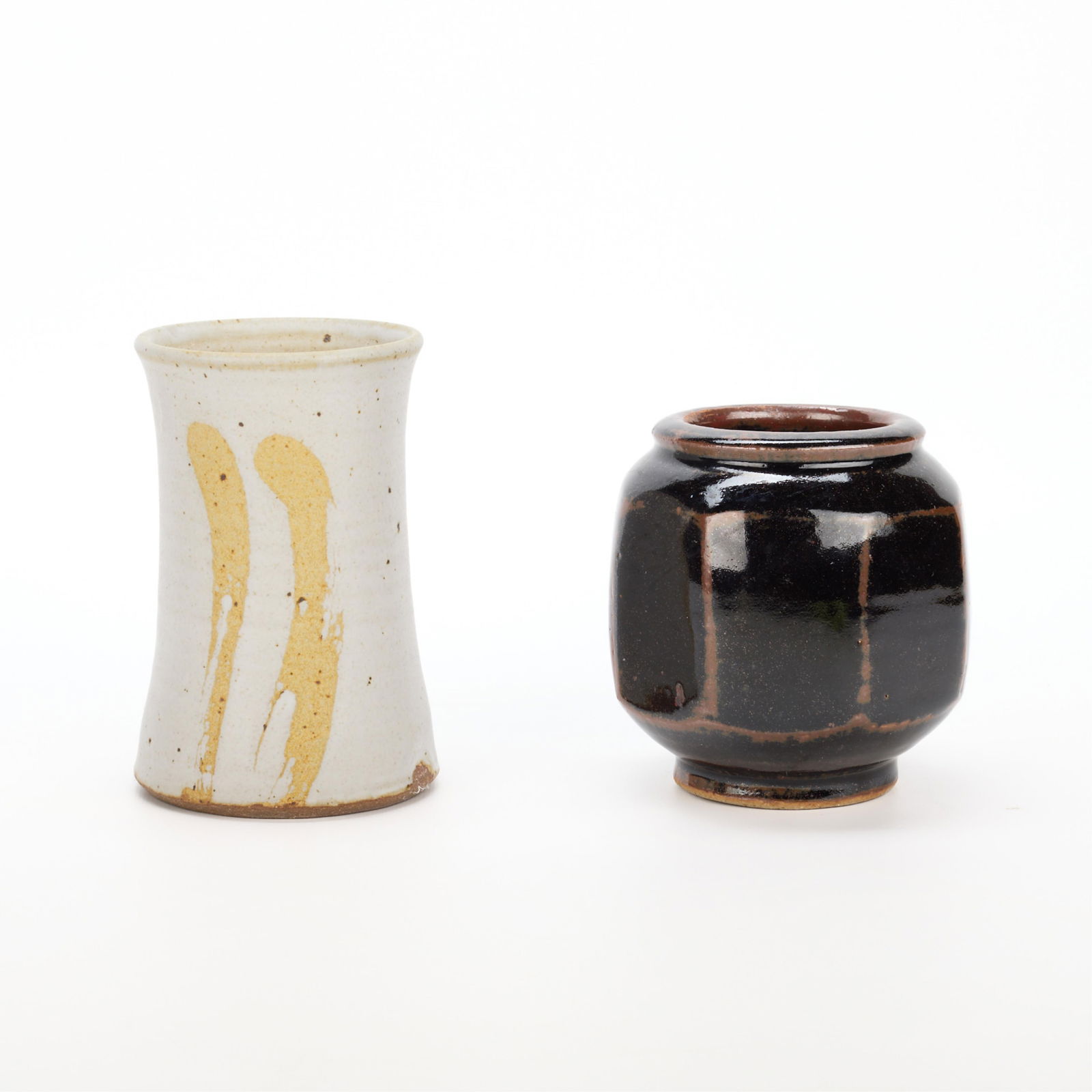 2 Peter & David Leach Studio Pottery Vessels: Group of two studio pottery vessels. Including:David Leach (English, 1911-2005). Stoneware with tenmoku glaze vase. Of faceted form, the glaze applied with resist technique. Impressed mark along the u