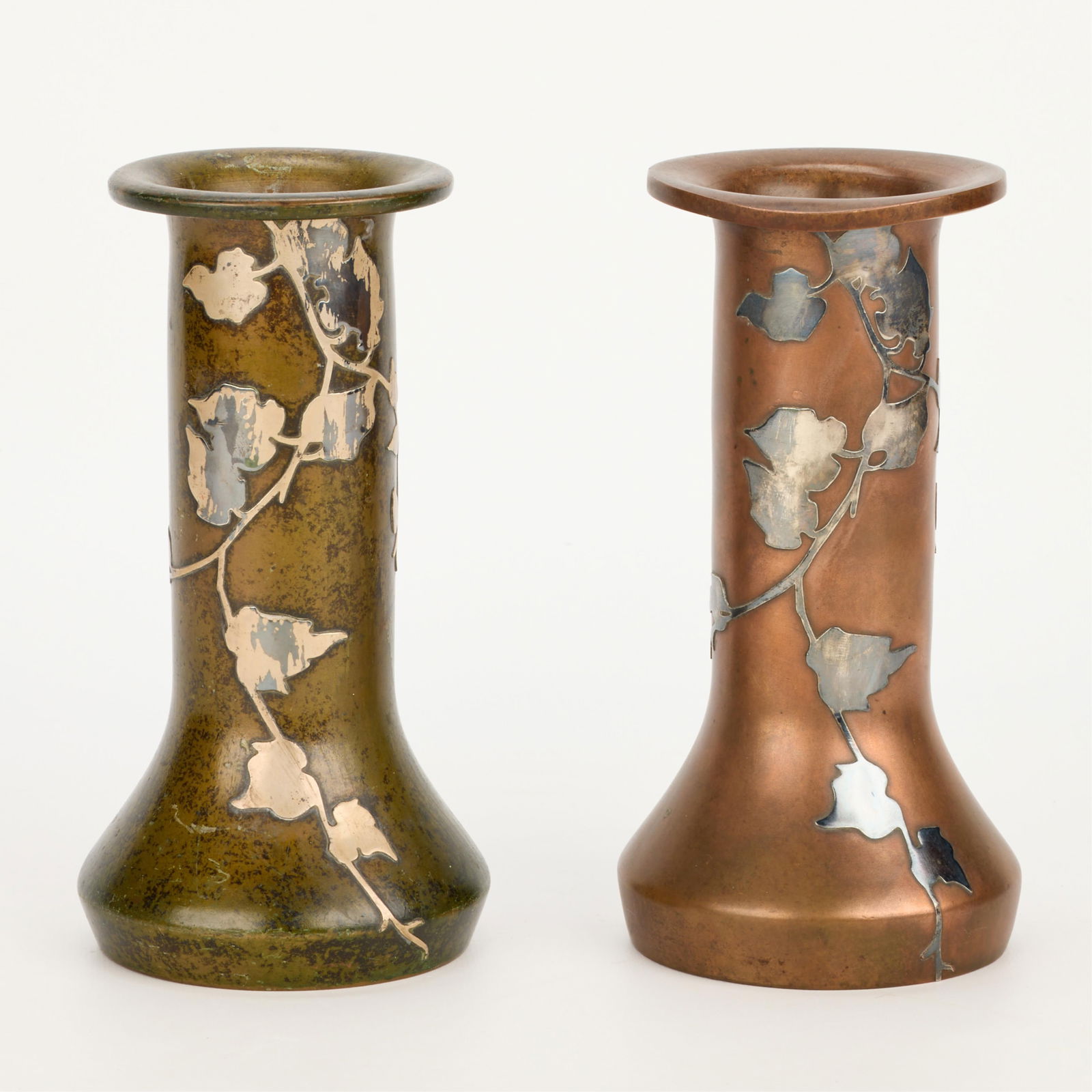 2 Heintz Arts & Crafts Bronze 3596C Floral Vases: Heintz Art Metal Shop, New York, United States. Group of two Arts & Crafts bronze vases, ca. 1912. Each featuring sterling silver overlay depicting foliate motifs. One with a green verde patina. Each