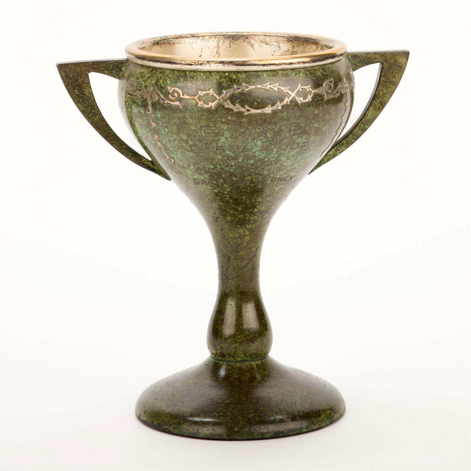 Attr. Heintz Arts & Crafts Verde Bronze Trophy Cup: Attributed to Heintz Art Metal Shop, New York, United States. Arts & Crafts bronze "P.G.C. Class B Cup" two-handled chalice or loving cup trophy, 1913. With sterling silver overlay depicting geometric