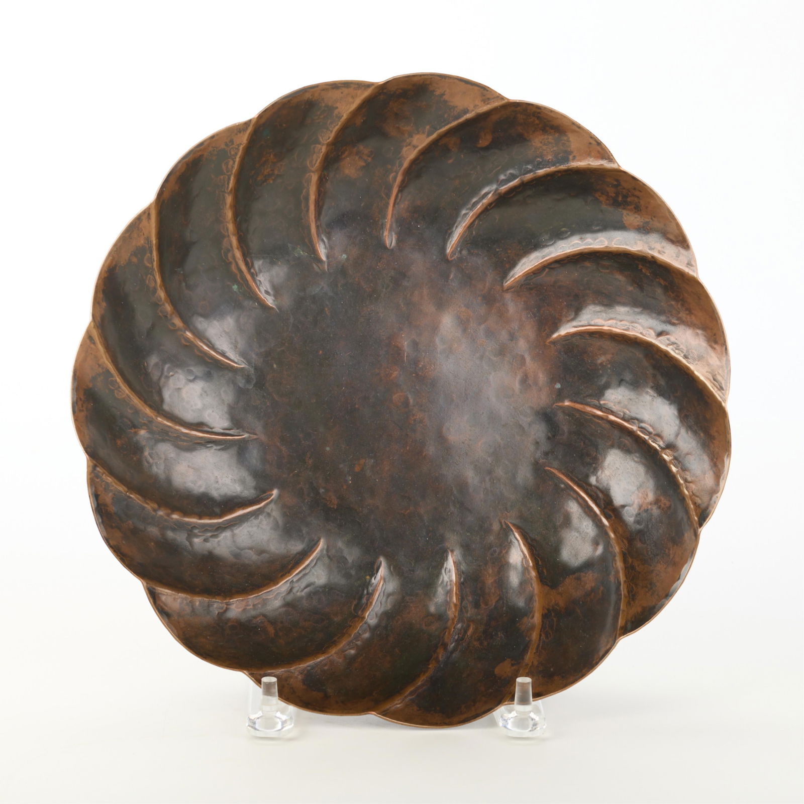 John Joseph Brennan Hammered Copper Fruit Bowl: John Joseph Brennan (American, 20th century). Arts & Crafts hand-wrought and hammered fruit bowl or rounded dish, ca. 1910. Of fluted, spiral form with a scalloped rim. With maker's mark along the