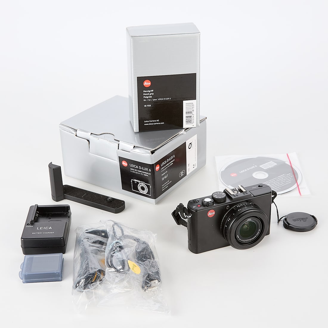 Leica D-Lux 6 Camera w/ Adapter: Leica, Germany. Digital camera, D-Lux 6, Serial #4504399. Black finish with built-in Vario-Summilux f1.4-2.3 24-90mm lens, 18733 handgrip with box, battery charger, CD-ROM instructions/manual, and add