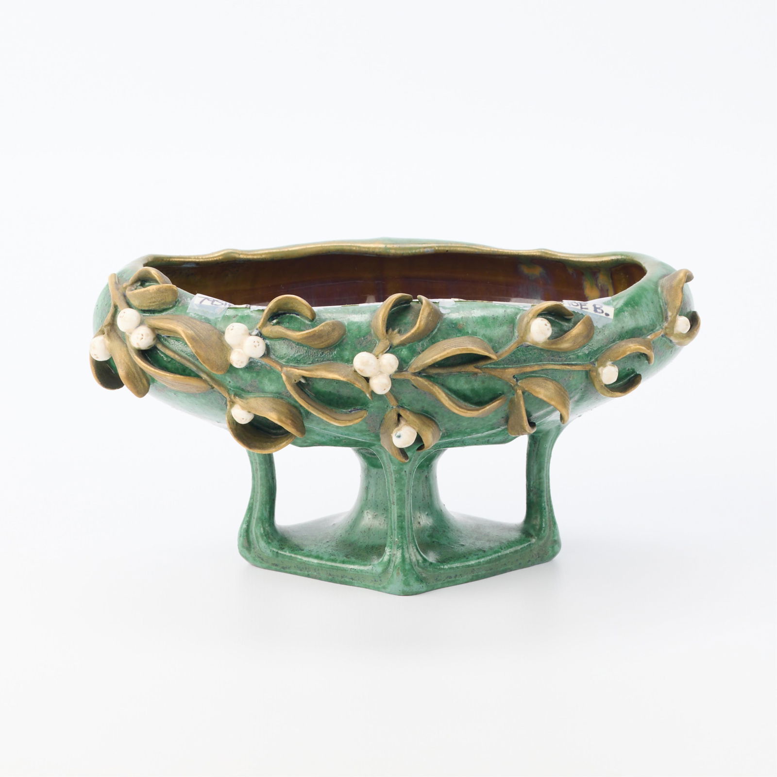 Art Nouveau European Pottery Mistletoe Compote: European Art Nouveau ceramic compote or pedestal dish, early 20th century. Depicting a mistletoe motif against green ground. With illegible stamp along the underside.Height: 4 1/2 in x width: 8 1/2 in