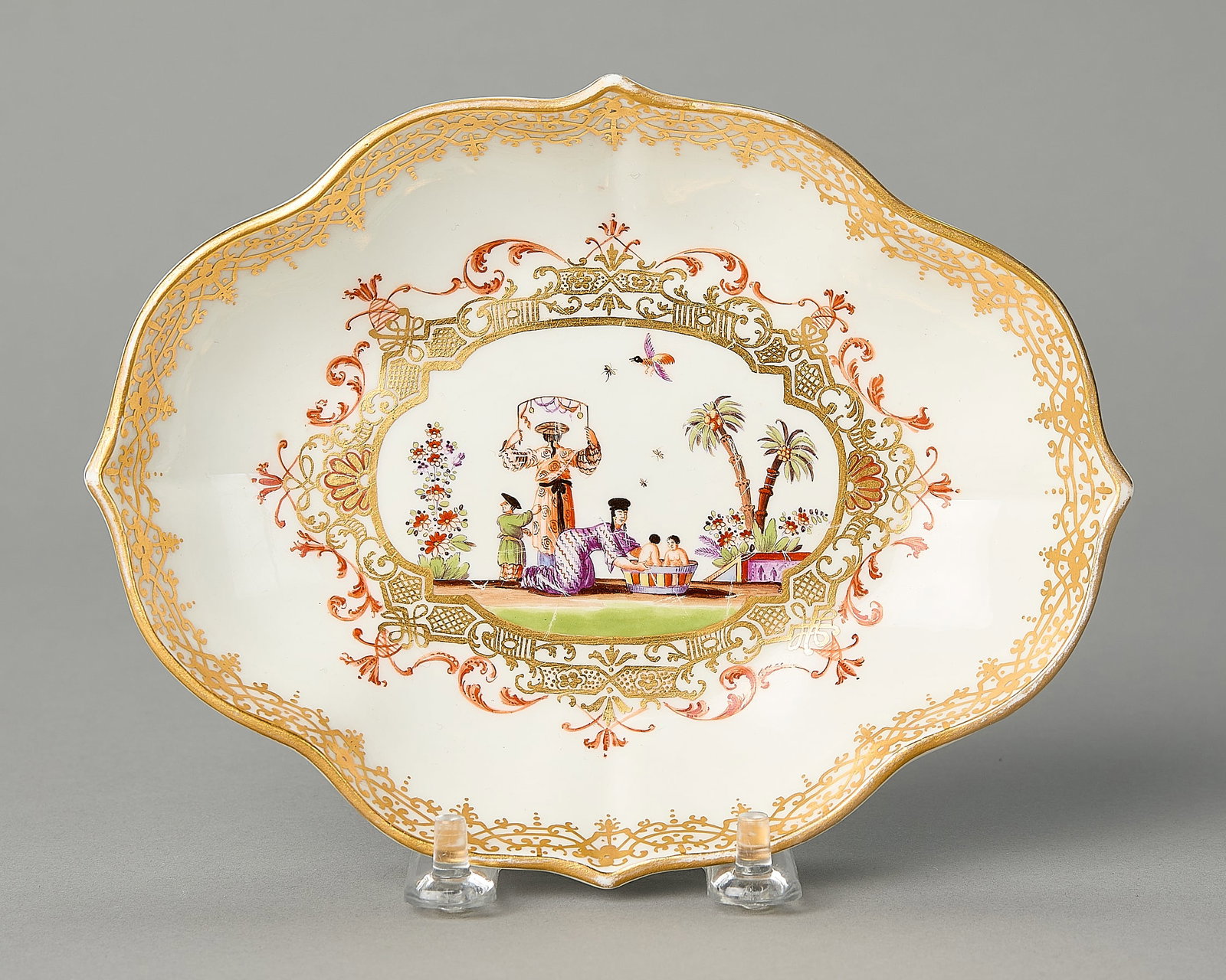 Meissen Quatrefoil Spoon Tray ca. 1730: Meissen, Germany. A porcelain quatrefoil spoon tray, ca. 1730. Painted in the manner of J.G. Herold with Chinoiseries figures within a gilt, iron-red, and puce cartouche. Gilder's mark "J." along the 