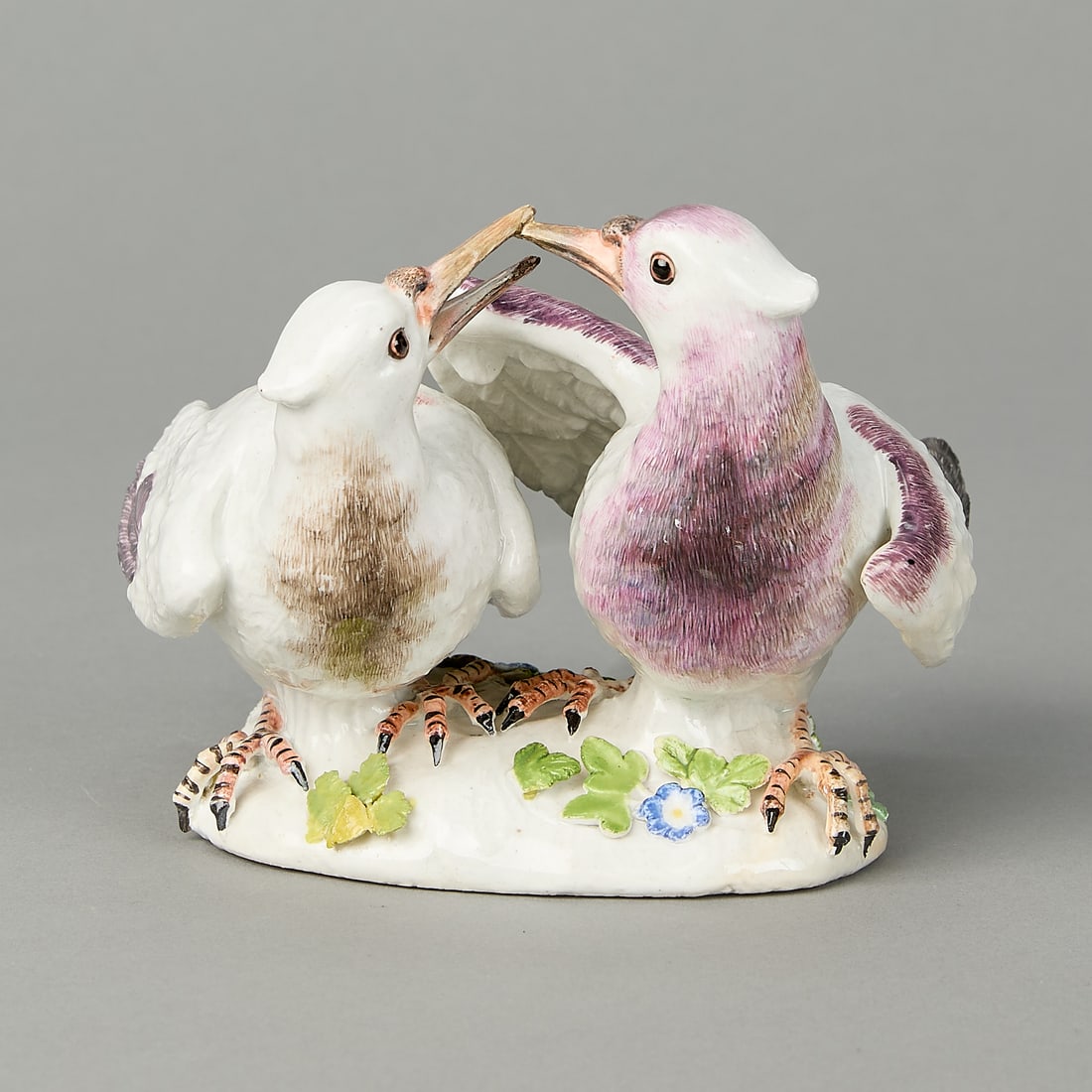 Meissen Billing Doves Model ca. 1738: Meissen, Germany. Modelled by J.J. Kandler. Porcelain model of a pair of billing doves, ca. 1738. Painted with white, purple-brown, and gray feathers. Standing on a mound with applied flowers. Provena