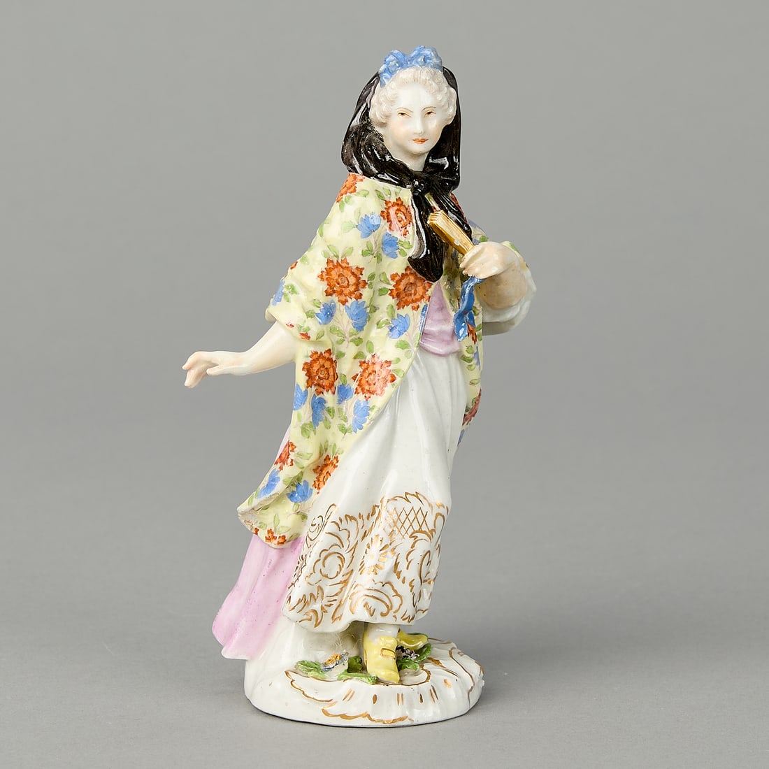 Meissen Cries of London Figure ca. 1754: Meissen, Germany. Modelled by J.J. Kandler and P. Reinicke. Porcelain figure from the Cries of London Series, ca. 1754. The figure in a black scarf, white dress with gold hem, and yellow shawl with br