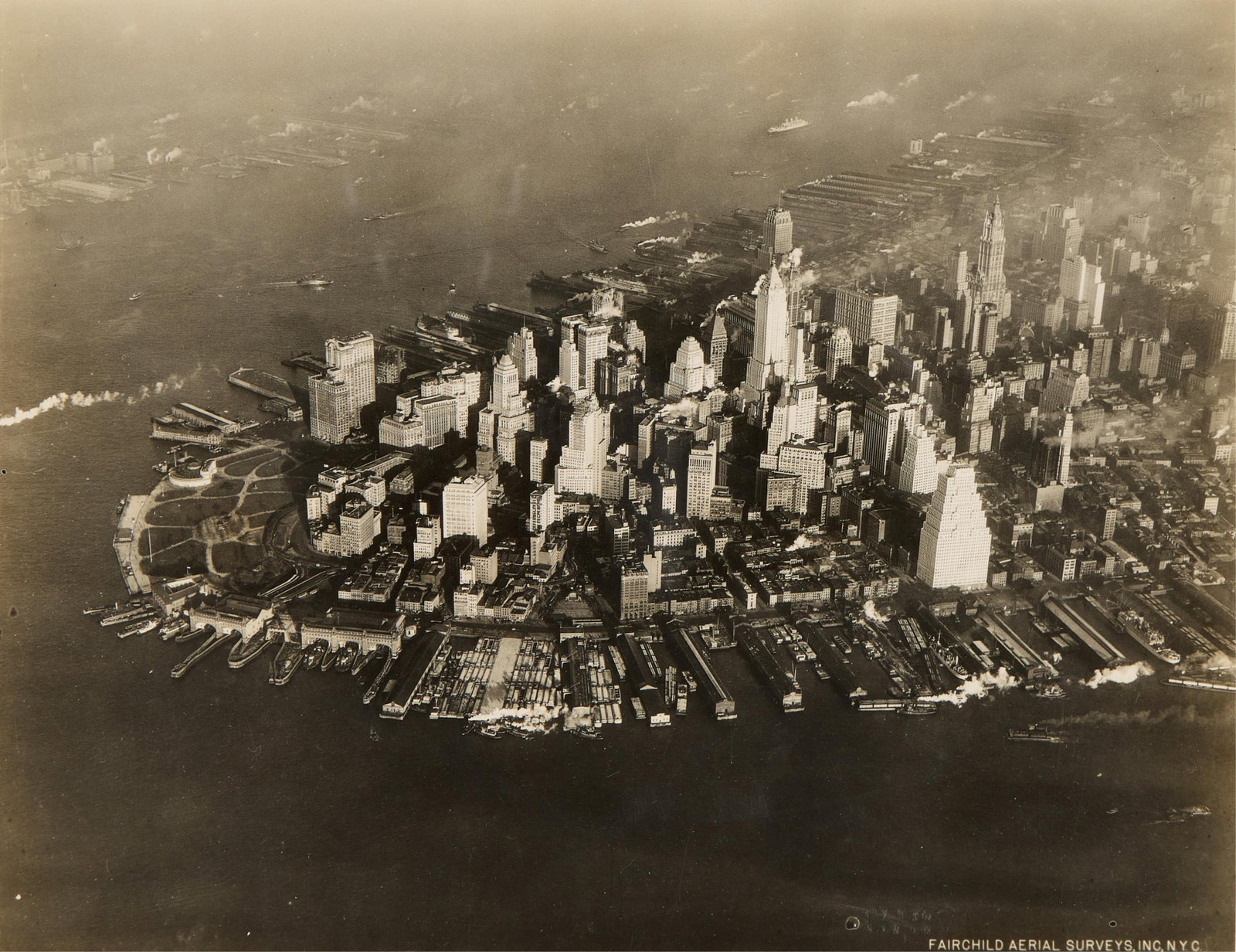 Fairchild Aerial Surveys Manhattan NYC Photograph: Fairchild Aerial Surveys, Inc., United States. Black and white photograph depicting an aerial view of Manhattan amongst the New York City skyline, ca. early 20th century. Ink stamped along the verso. 