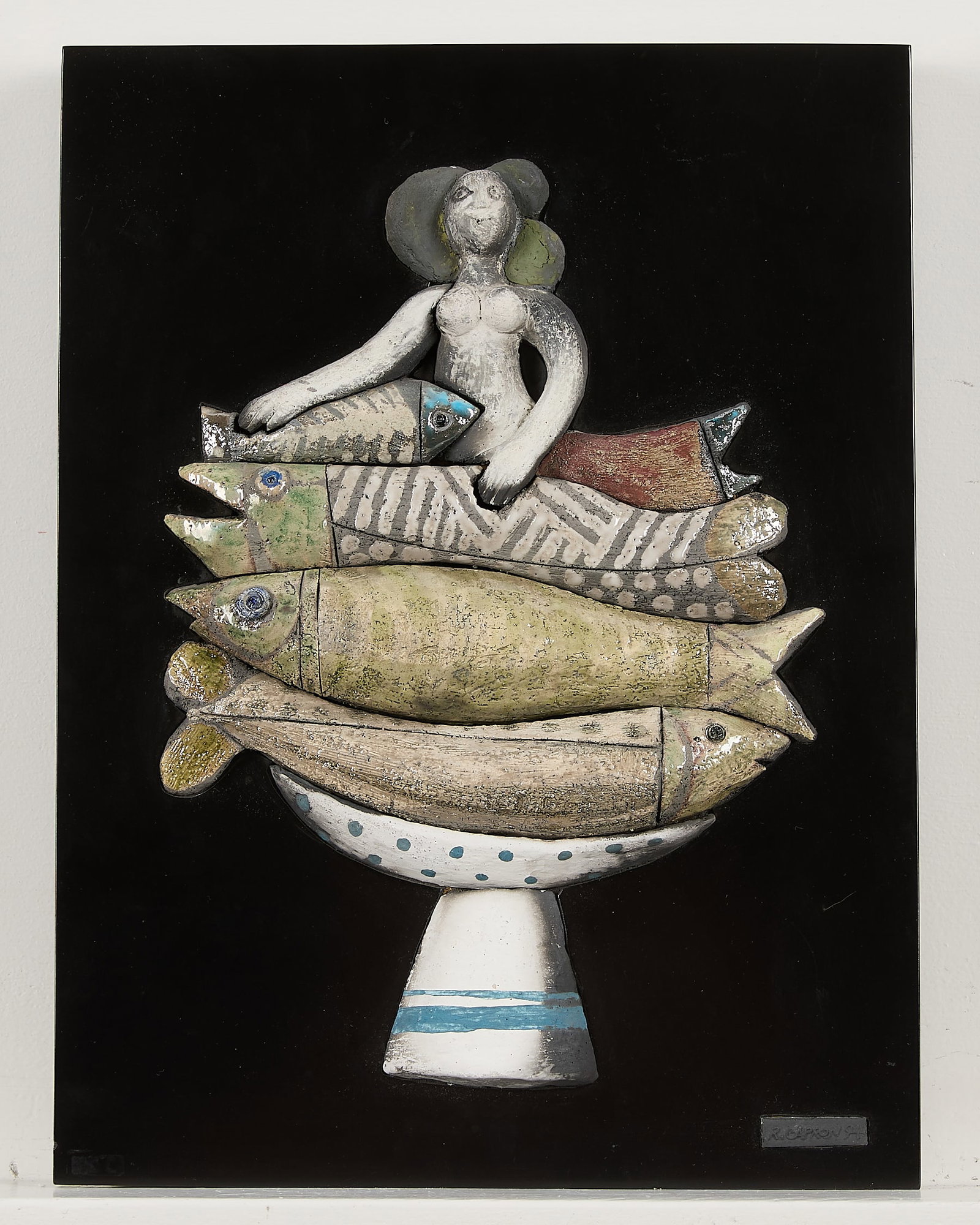 Roger Capron Fish Woman Ceramic Wall Sculpture: Roger Capron (French, 1922-2006). Ceramic wall sculpture featuring a female figure seated atop a pile of fish housed in a blue and white footed bowl. Embossed signature and dated 1994 along a plaque a