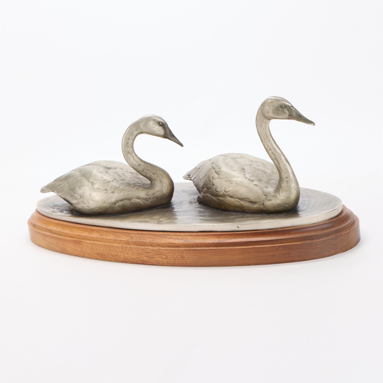 Chester Comstock "Swan Lake" Bronze Sculpture 1980: Chester Comstock (American, 20th/21st century). Bronze sculpture titled "Swan Lake," 1980. Depicting a pair of swans gliding across a pond. Mounted atop a wooden base. Incised signature, dated, and ed