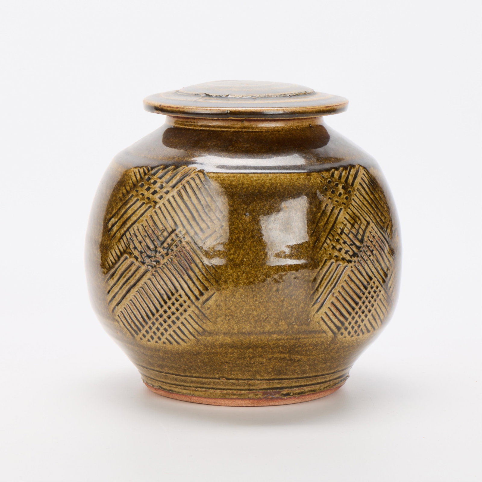 Warren MacKenzie Studio Pottery Lidded Jar Marked: Warren MacKenzie (American, 1924-2018). Studio pottery ceramic lidded jar with incised decoration. Stoneware with glossy ame glaze. Stamped along the footrim. Warren MacKenzie was a renowned Minnesota
