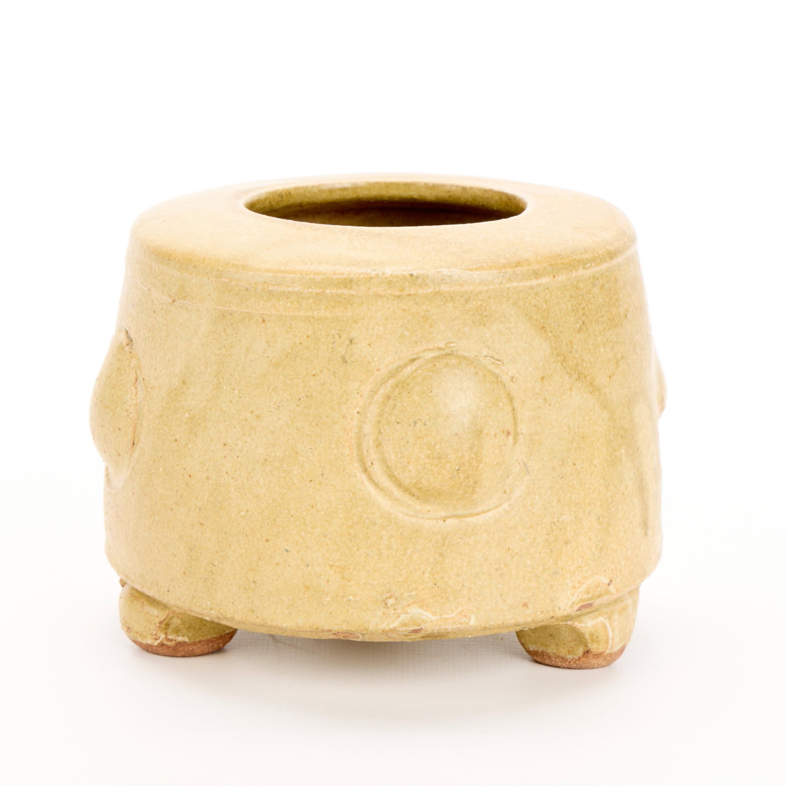 Warren MacKenzie Ikebana Pottery Vase - Marked: Warren MacKenzie (American, 1924-2018). Studio pottery ceramic ikebana floral vase with raised circular motifs. Stoneware with a matte yellow glaze and tripod footed base. Stamped along footrim. Warre