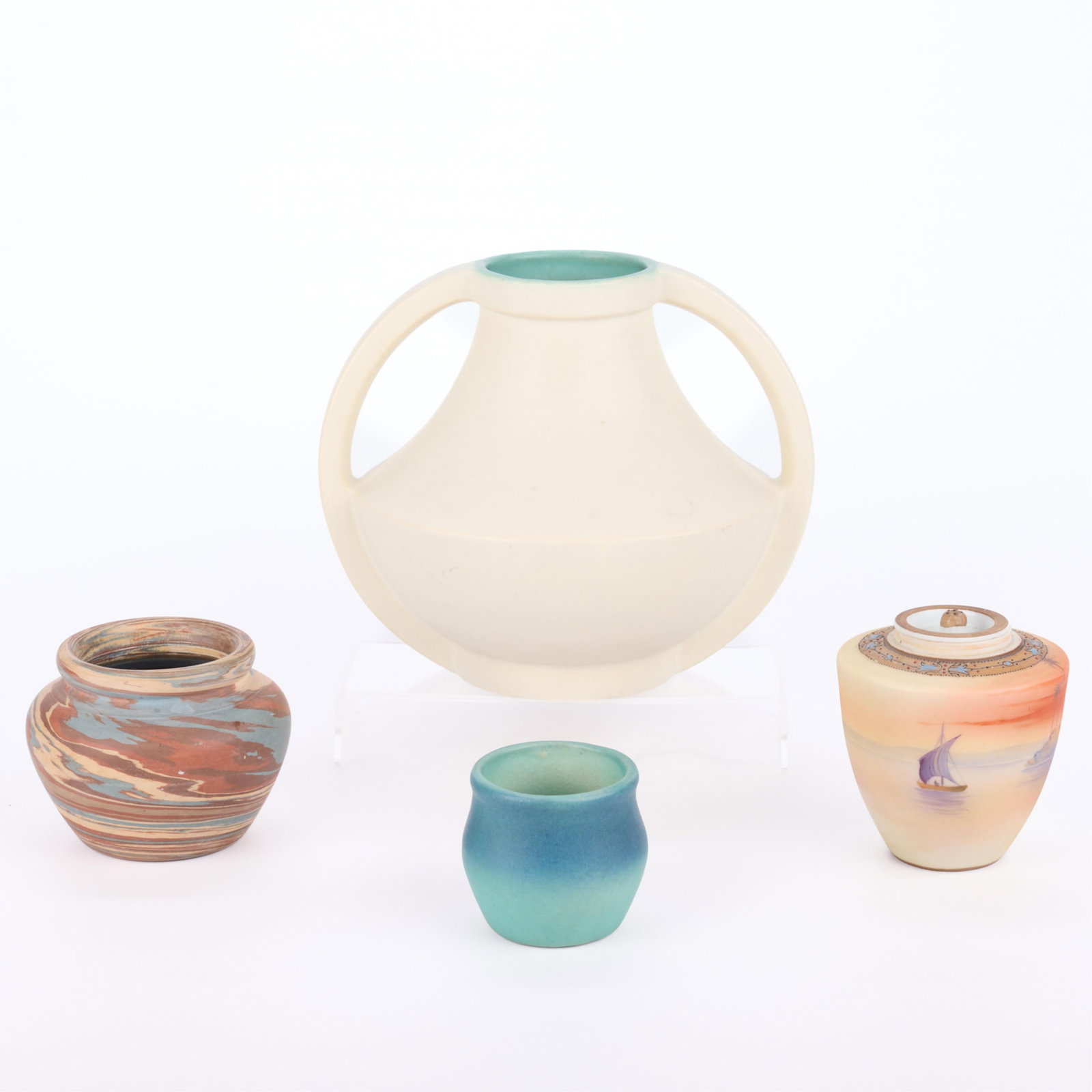 4 Art Pottery Ceramic Vessels: Group of four art pottery vessels, 20th century. Including: Niloak Pottery, United States. One small Arts & Crafts "mission swirl" art pottery vase, 20th century. With recessed neck. Marked along the 