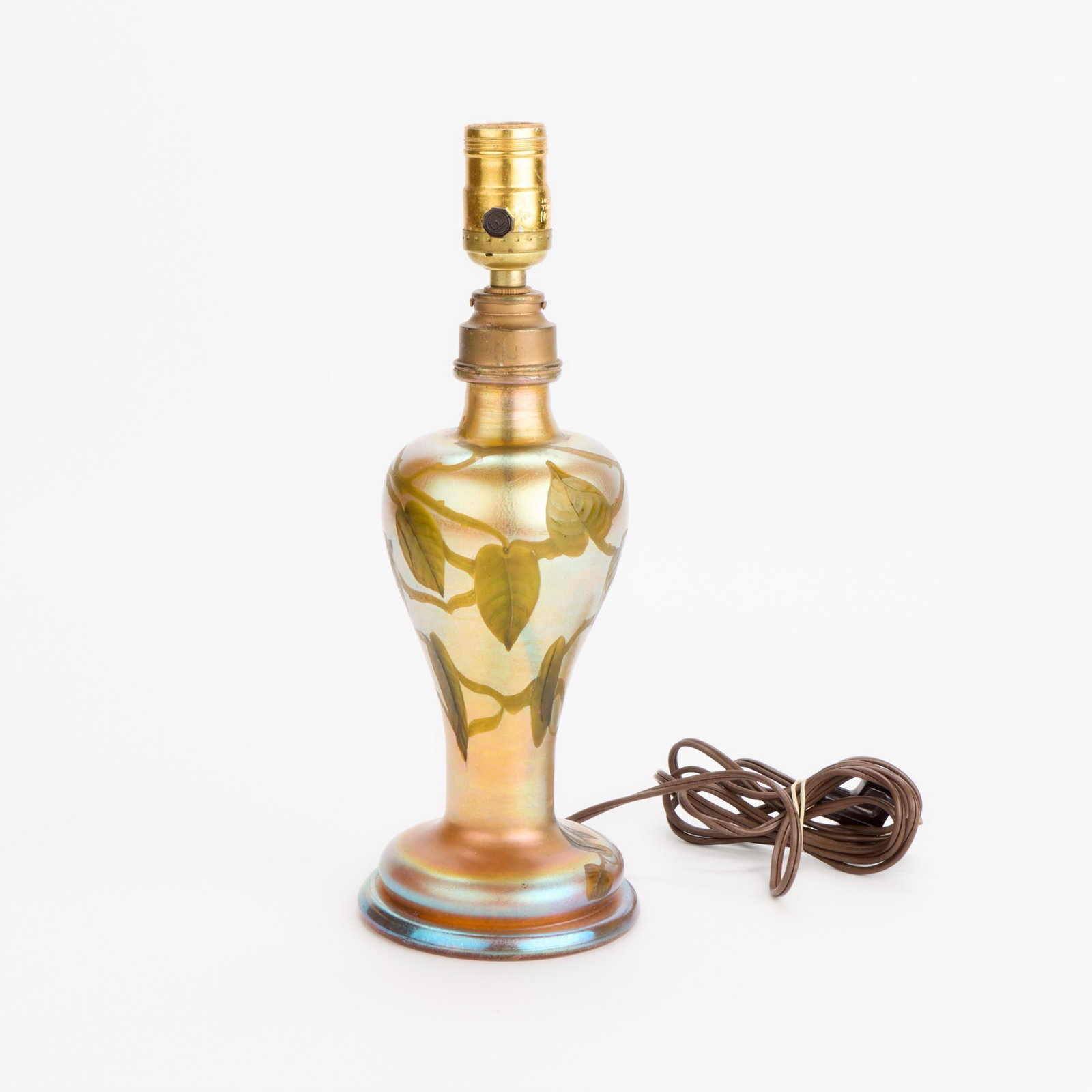 L.C. Tiffany "Leaf & Vine" Favrile Glass Lamp Base: Louis Comfort Tiffany (American, 1848-1933) for Tiffany Studios, United States. "Leaf and Vine" motif lamp base featuring iridescent gold Favrile glass decorated with carved intaglio green leaves and 