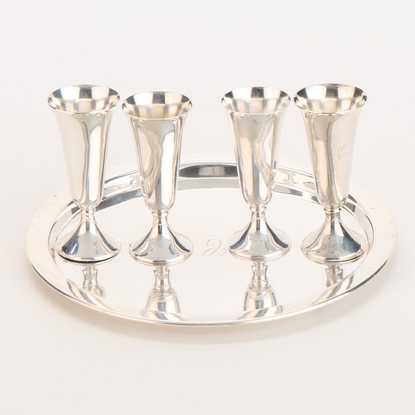 4 Sterling Glasses w/ Reed & Barton Tray 5.78 ozt: Group of five pieces of sterling silver, 20th century. Including: Fisher Silversmiths, United States. Four sterling silver aperitif glasses or cups. Each marked "Fisher" and "Sterling." Each glass mon