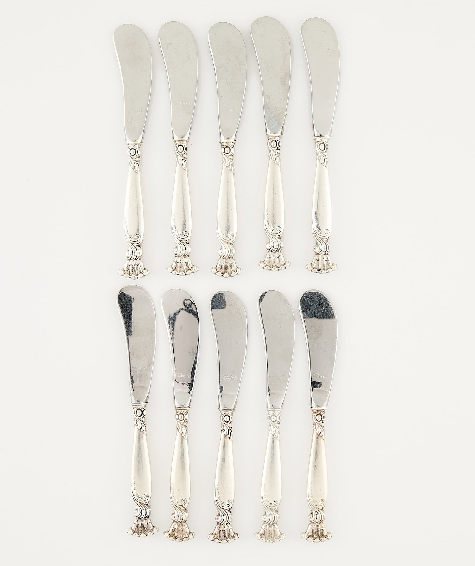 10 Wallace Sterling Romance of Sea Knives 442.6 g: Wallace Silversmiths, United States. Set of ten sterling silver "Romance of the Sea" pattern butter spreaders, 20th century. With scalloped shell-motif terminals. With pattern name along the handle; t