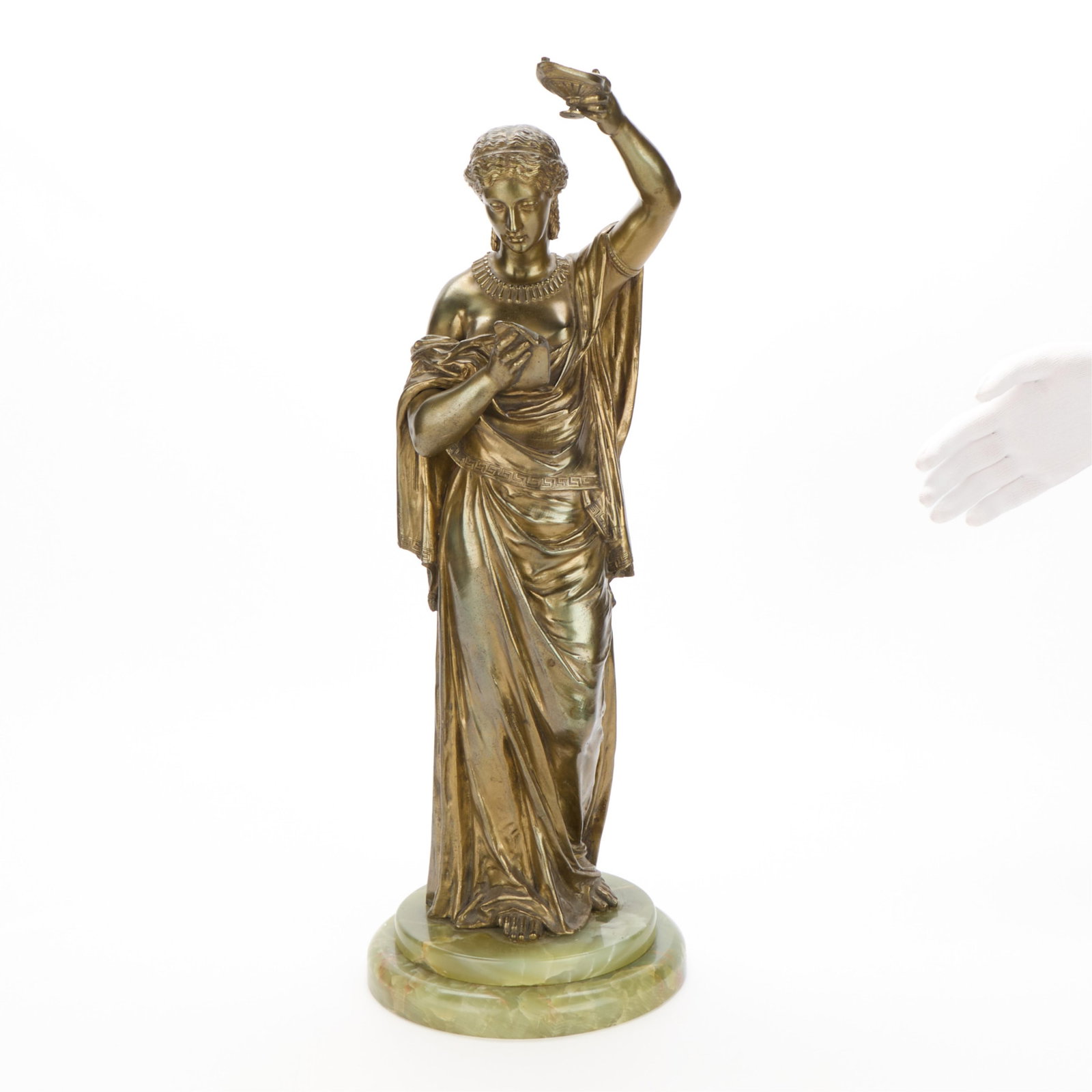 French School Neo-Classical Woman Figural Bronze: French School bronze sculpture depicting a Neo-Classical woman raising an ancient Greek oil lamp above her downturned head, her gaze directed towards a text grasped by her right hand, late 19th-early 