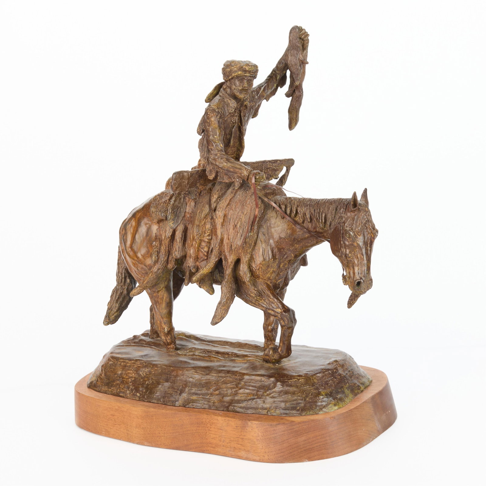 J. Shirly Bothum "The Rare Skin" Bronze 1977: J. Shirly Bothum (American, 1937-2003). Bronze sculpture titled "The Rare Skin," 1977. Depicting a pioneer man seated atop a horse, holding high the bounty of his hunt in his left hand. Incised signat