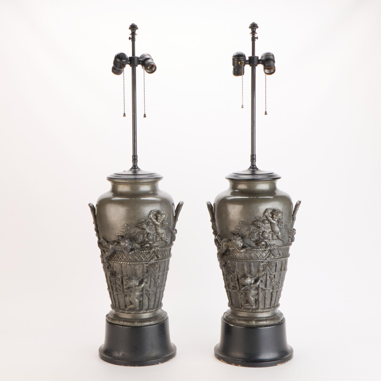 Pr Auguste Moreau Bronze Putti Vases as Lamps: Auguste Moreau (French, 1834-1917). A pair of patinated bronze vases mounted as lamps. Each decorated with putti and baskets in high relief on a baluster-form base. Signed along the lower edge. Proven