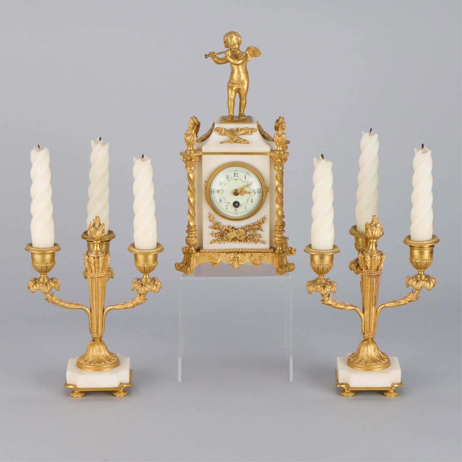 19th c. French Ormolu Marble Mantel Garniture Set: Three-piece French Louis XVI style marble and gilt bronze or ormolu-mounted mantel garniture set, 19th century. Comprising two three-light candelabras and a central boudoir clock within a white marble