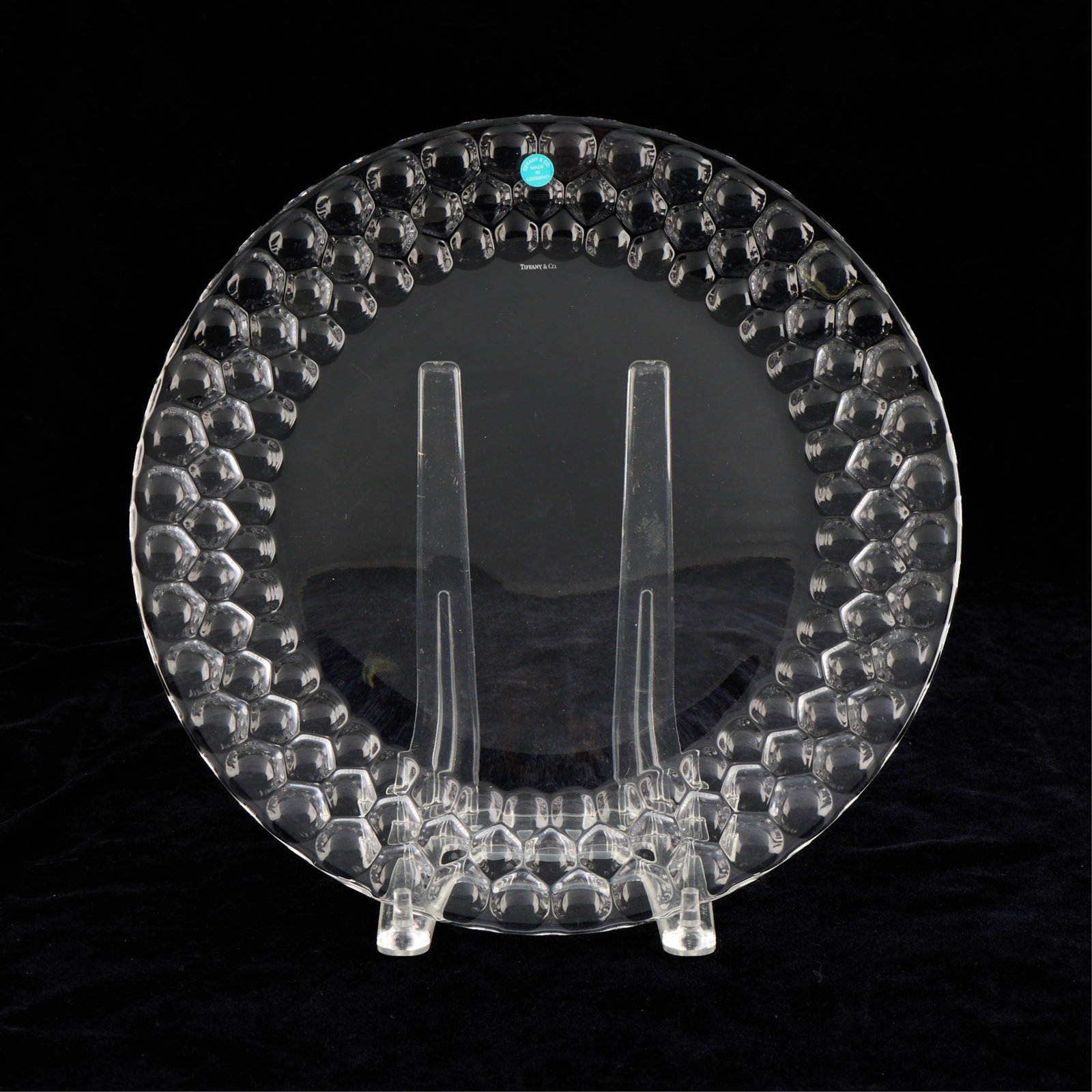 Tiffany & Co. German Crystal Honeycomb Platter: Tiffany & Co., Germany. Crystal glass platter or charger with a decorative textured honeycomb design along the border. With a Tiffany sticker affixed along the surface. Diameter: 12 1/2 in. Metro 14