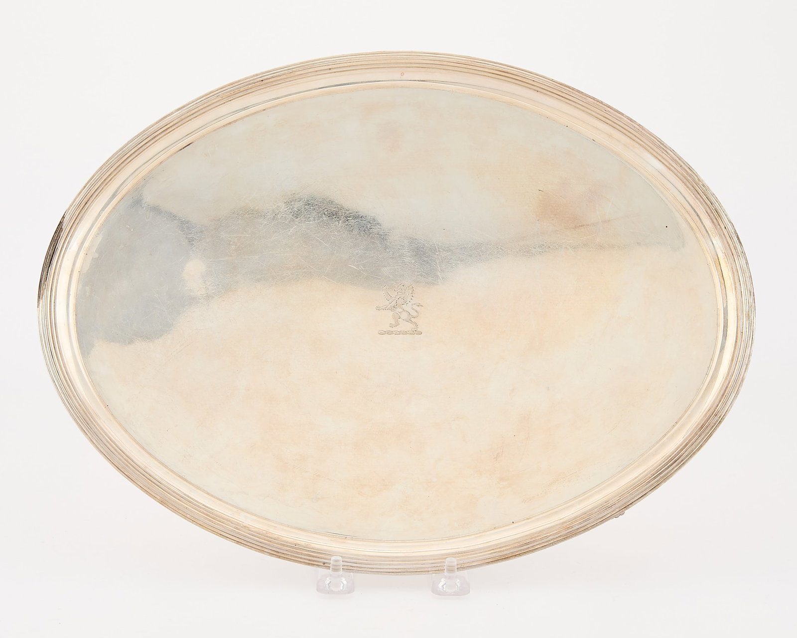 19th c. English Sterling Footed Tray 30.97 ozt: English Georgian sterling silver oval tray with reeded border mounted on four feet, early 19th century. With stamped rampant lion along the center. Initialed "WB" along the underside, possibly indicat