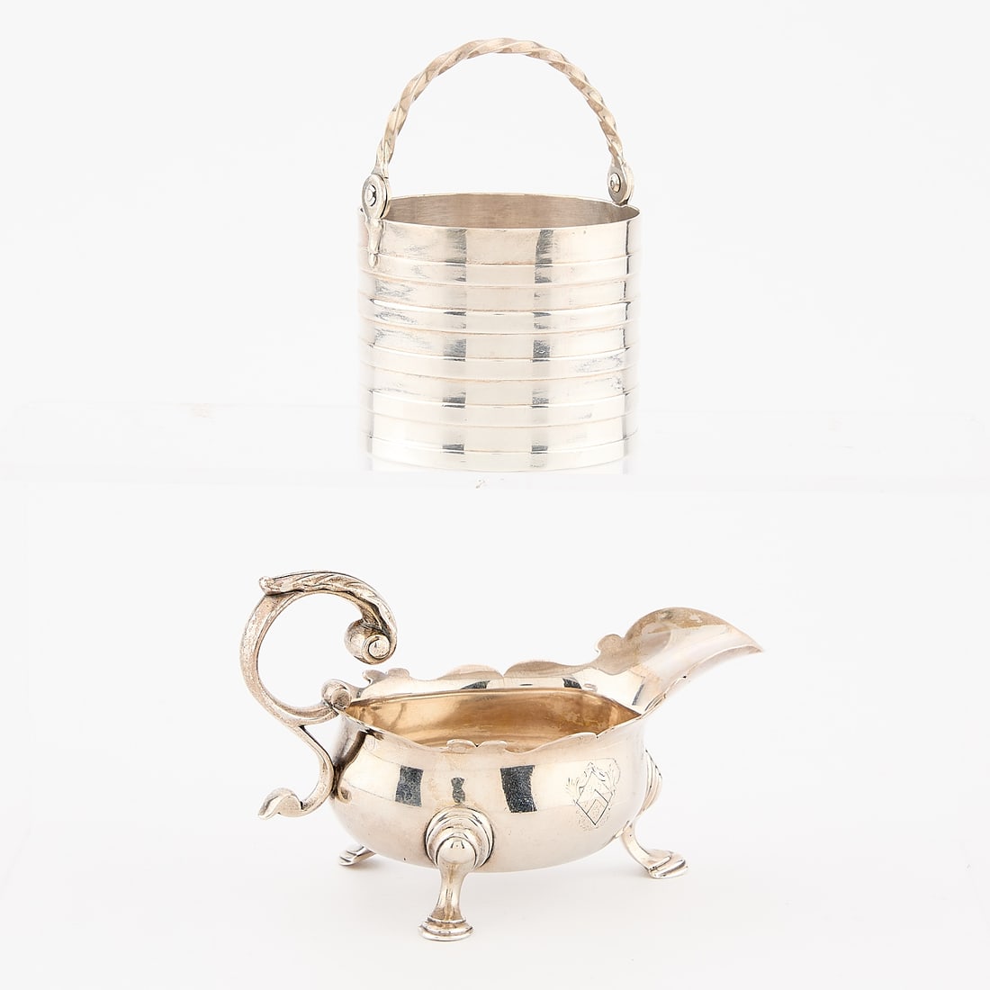2 English Sterling Silver Vessels 7.21 ozt: Group of two English sterling silver vessels. Including one small cream pail with banded design, surmounted by a twisted handle, and one gravy or sauce boat. The sauceboat with stamped lion passant in