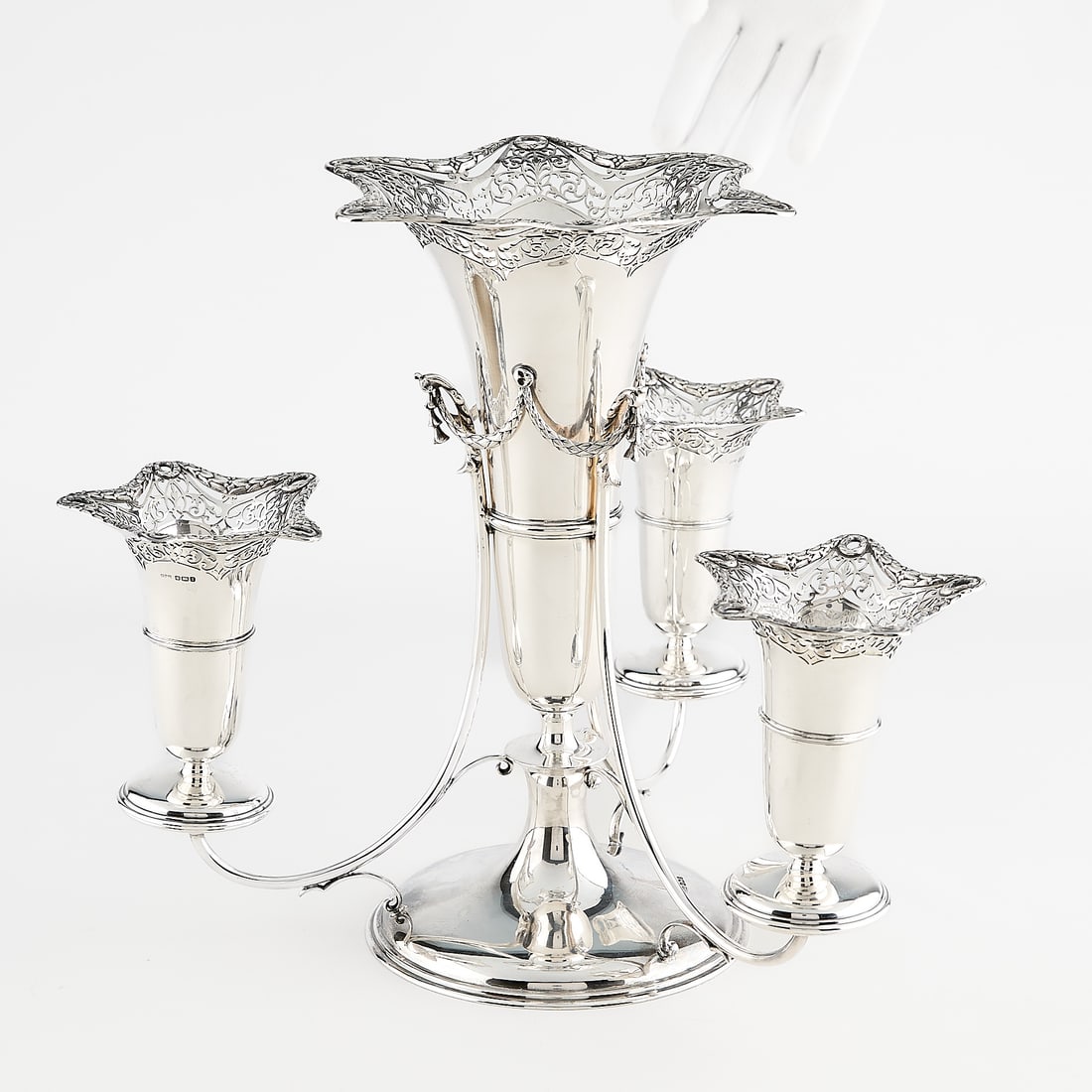 19th c. James Dixon Sterling Silver Epergne 50 ozt: James Dixon & Sons, England. Sterling silver epergne comprised of round base with main funnel form vase with pierced work, swag-like motifs connect to the three arms with supports for removable smalle