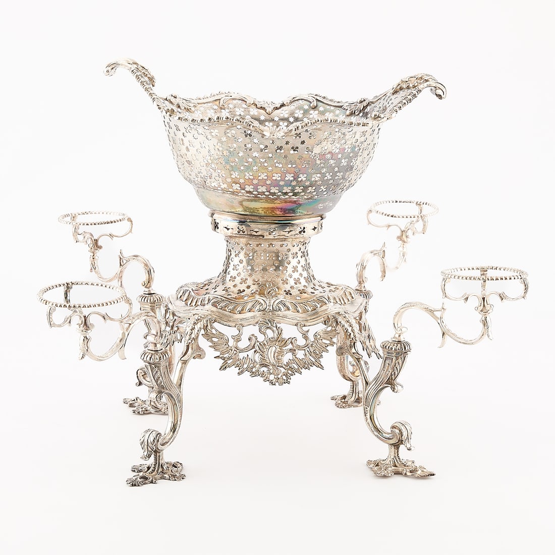 Antique Silverplate Pierced Epergne 2,085 g: Silverplated epergne comprised of four feet and a base with scrolling and pierced work. There are slots for four arms to insert into. Without the dishes to sit in the arms. With main element of simila