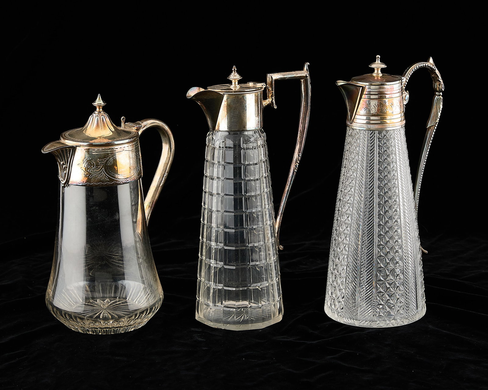 3 Silver Mounted Glass Pitchers: Group of three silver mounted glass pitchers, including one marked Suckling & Empsons. Provenance: The Distinguished Collection of Leo & Doris Hodroff. Height ranges from 10 in to 11 in; width ranges 