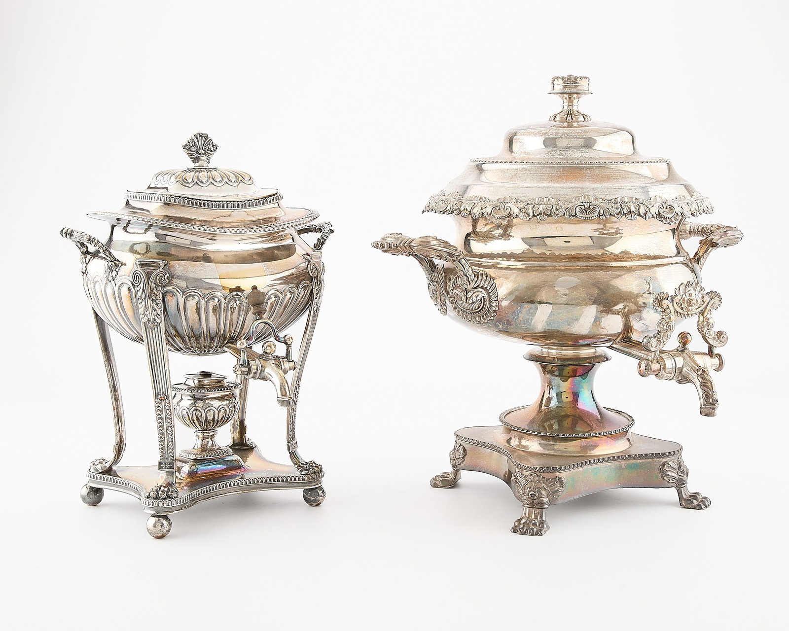 2 English 19th Century Silverplated Urns: Two large English silver plated hot water, tea or coffee urns, late 19th century. One on four claw feet with round reciptial and scrolling and ornate spout. One on a base with four ball feet surmounte
