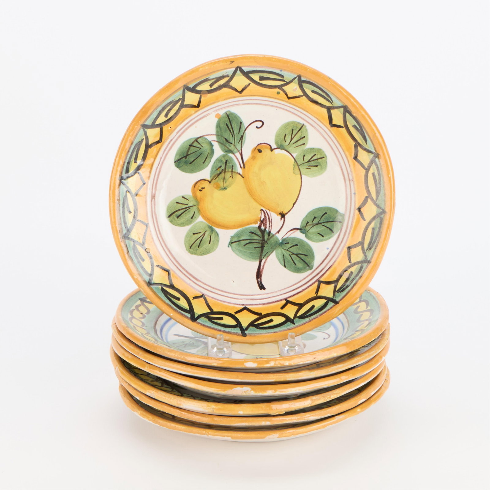 7 Italian Pottery Ceramic Lemon Lunch Plates: Set of seven Italian ceramic lunch plates decorated with vibrant lemons and foliate motifs, 20th century. Marked "Made in Italy" along the underside. Provenance: The Distinguished Collection of Leo & 
