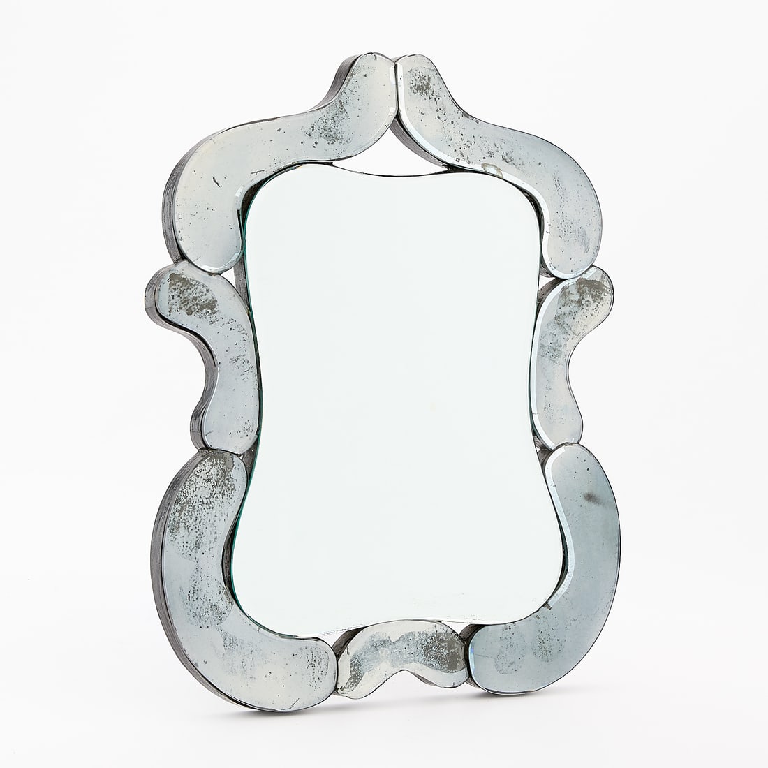 Hollywood Regency Venetian Style Beveled Mirror: Hollywood Regency Venetian-style beveled glass shield-shaped accent or dressing table mirror, 20th century. Provenance: The Distinguished Collection of Leo & Doris Hodroff. Height: 18 3/4 in x width: 