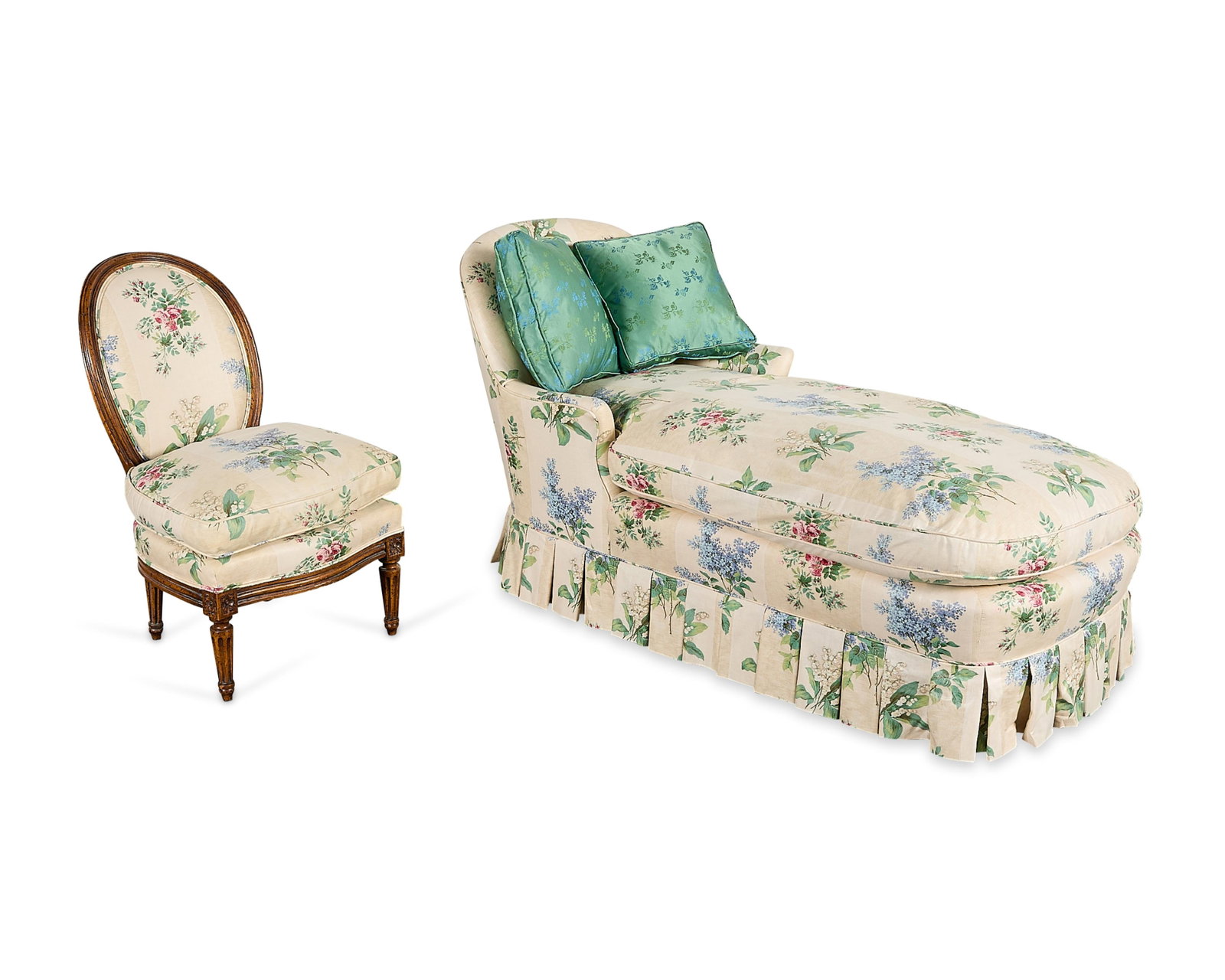 Louis XVI Style Chintz Chaise Lounge & Chair: Group of two chintz floral upholstered furniture pieces, 20th century. Including one chaise lounge with a pleated skirt, and one Louis XVI-style carved walnut chair with an oval back and carved rosett