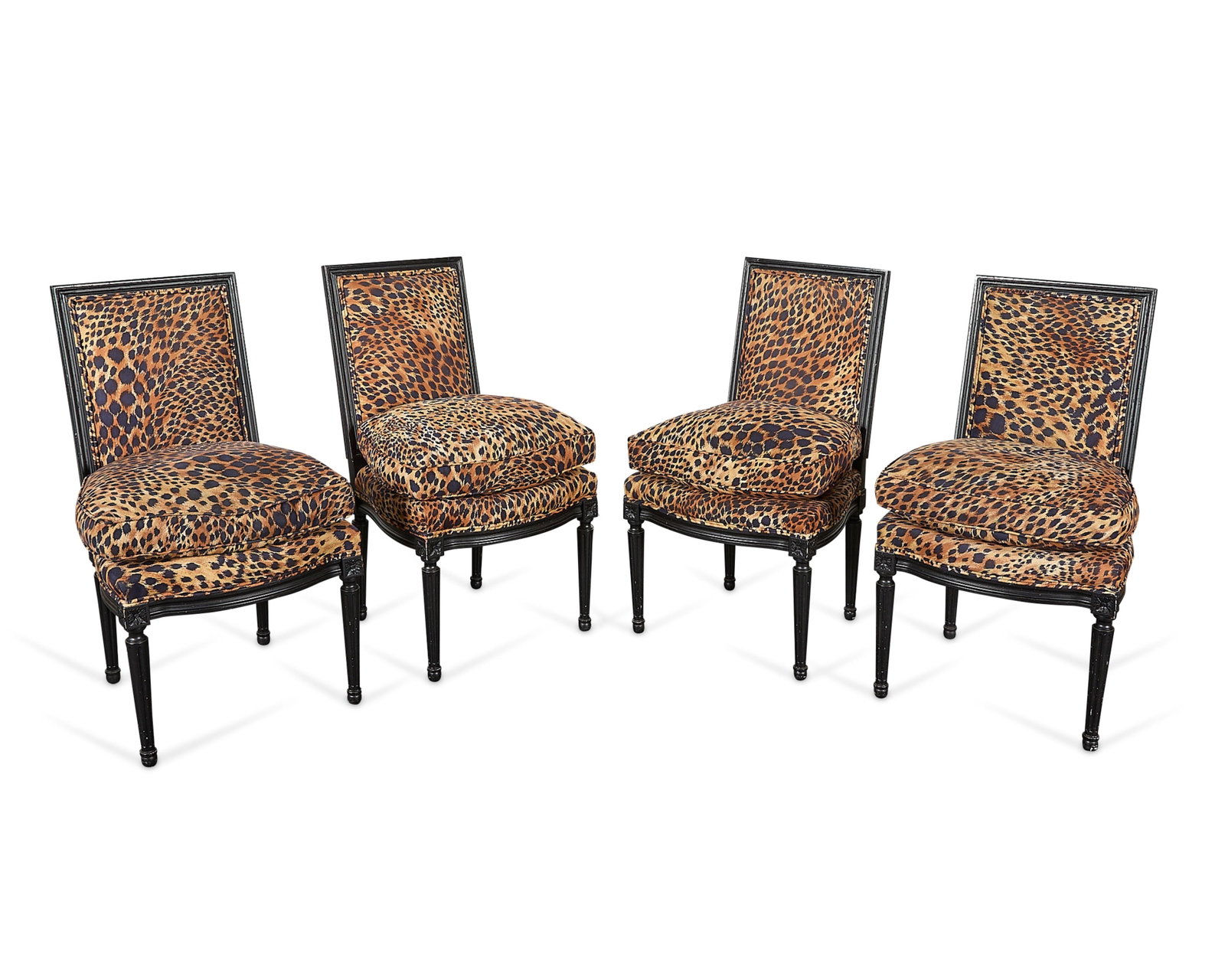 4 Ebonized Wood Leopard Print Dining Chairs: Set of four ebonized wood dining room chairs or chaises, 20th century. With leopard print upholstered backs, seats, and cushions. Atop reeded, tapered legs. Provenance: The Distinguished Collection of