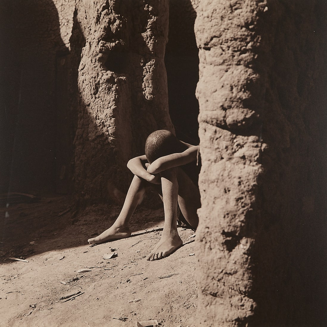 Lynn Davis B&W Figural Photograph 1997: Lynn Davis (American, b. 1944). Black and white photograph depicting a young boy seated on the ground covering his head; photographed in 1997, printed in 1999. Pen signed, dated, and editioned 2/10