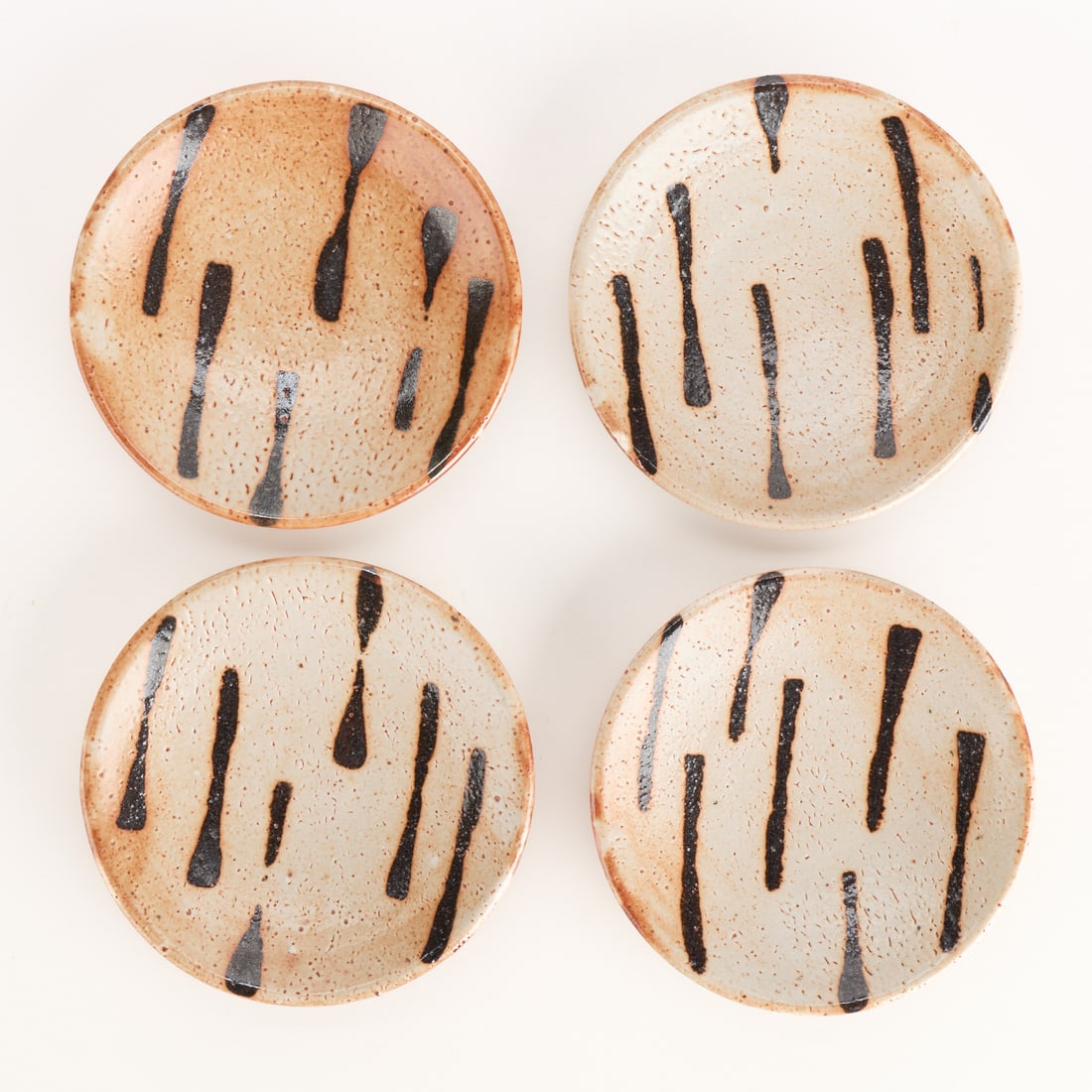 4 Warren MacKenzie Studio Pottery Plates - Marked: Warren MacKenzie (American, 1924-2018). Set of four studio pottery ceramic salad, dessert, or appetizer plates. Stoneware with shino glaze, featuring slip trails or MacKenzie's iconic finger swipe