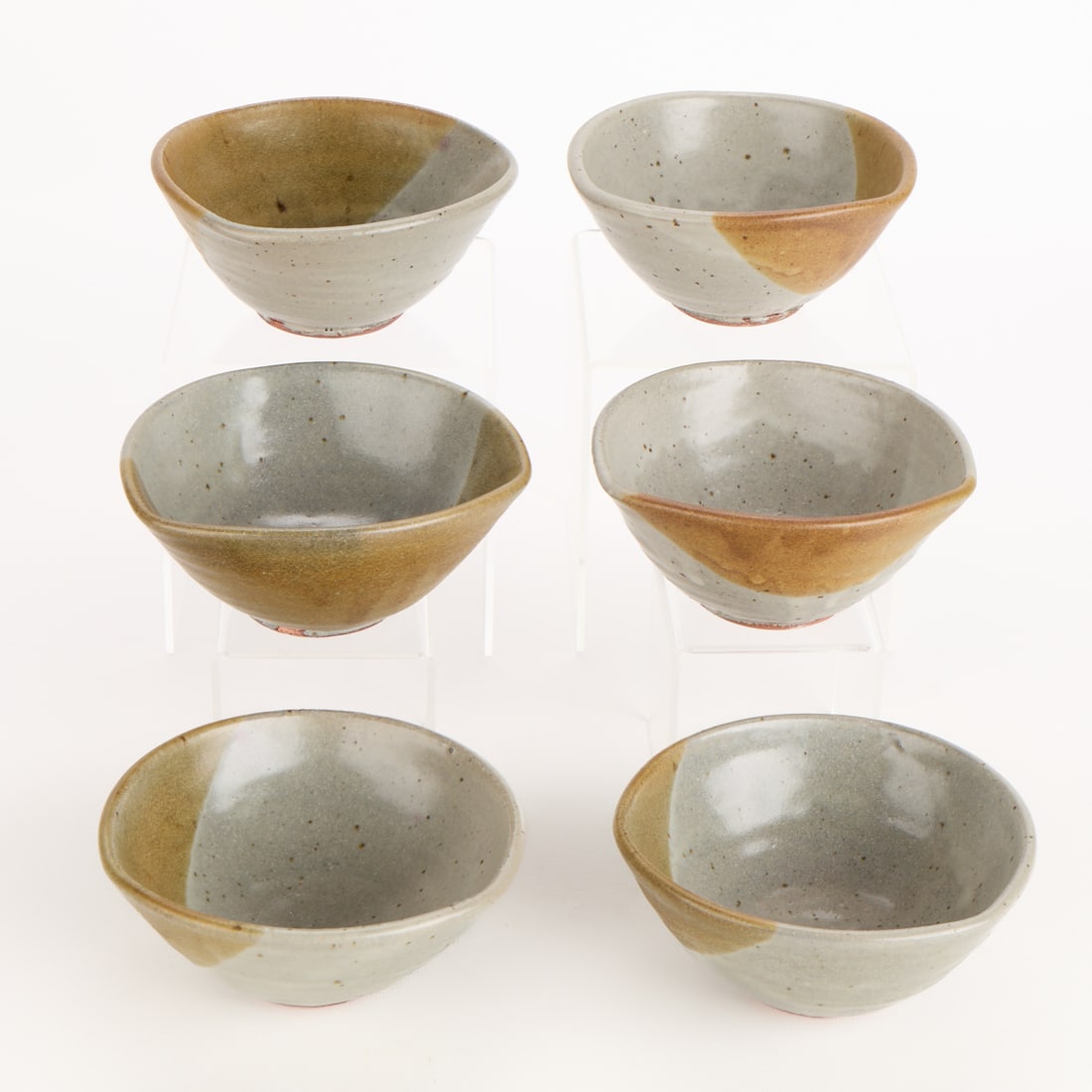 6 Warren Mackenzie Studio Pottery Bowls - Marked: Warren MacKenzie (American, 1924-2018). Set of six studio pottery ceramic bowls. Stoneware executed in two-toned light grey and caramel brown glazes. Each stamped along the underside. Warren