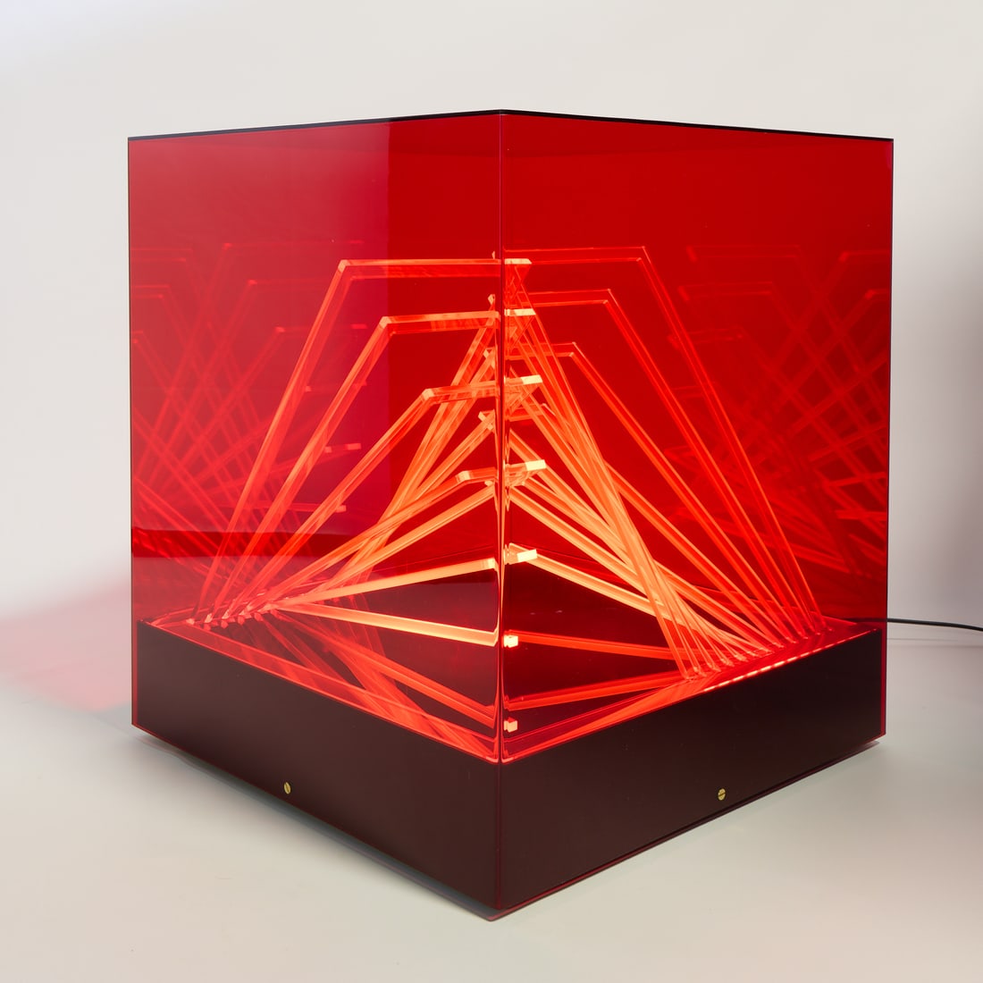 James Riviere "Cubo di Teo" Light Sculpture 1960s: James Riviere (Italian, b. 1949) for Centro Ricerche Arte Industria Lissone, Italy. Kinetic light sculpture table lamp in the "Cubo di Teo" design with translucent red colored Perspex of cube form, ci