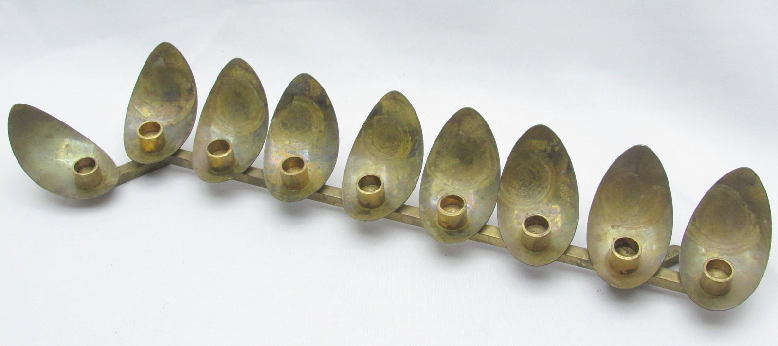 Modernistic Brass Hanukkah Menorah Designed by Yehuda (Ludwig) Wolpert: Modernistic Brass Hanukkah Menorah Designed by Yehuda (Ludwig) Wolpert, one of the New Bezalel School's most prominent teachers, designed in the shape of flames, marked, width: 31 cm. Light wear, pati