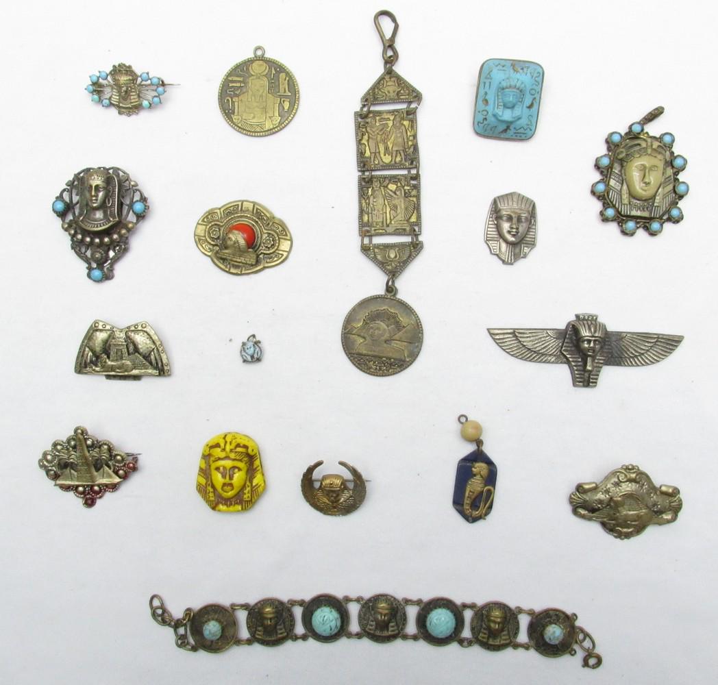 An Assortment Of 18 Vintage "Egyptian Revival" Fashion Jewelry Pieces: An Assortment Of 18 Vintage "Egyptian Revival" Fashion Jewelry Pieces, 20th century, mainly made of metal and glass designed/decorated with ancient Egyptian motifs: the head of the pharaoh king, the s