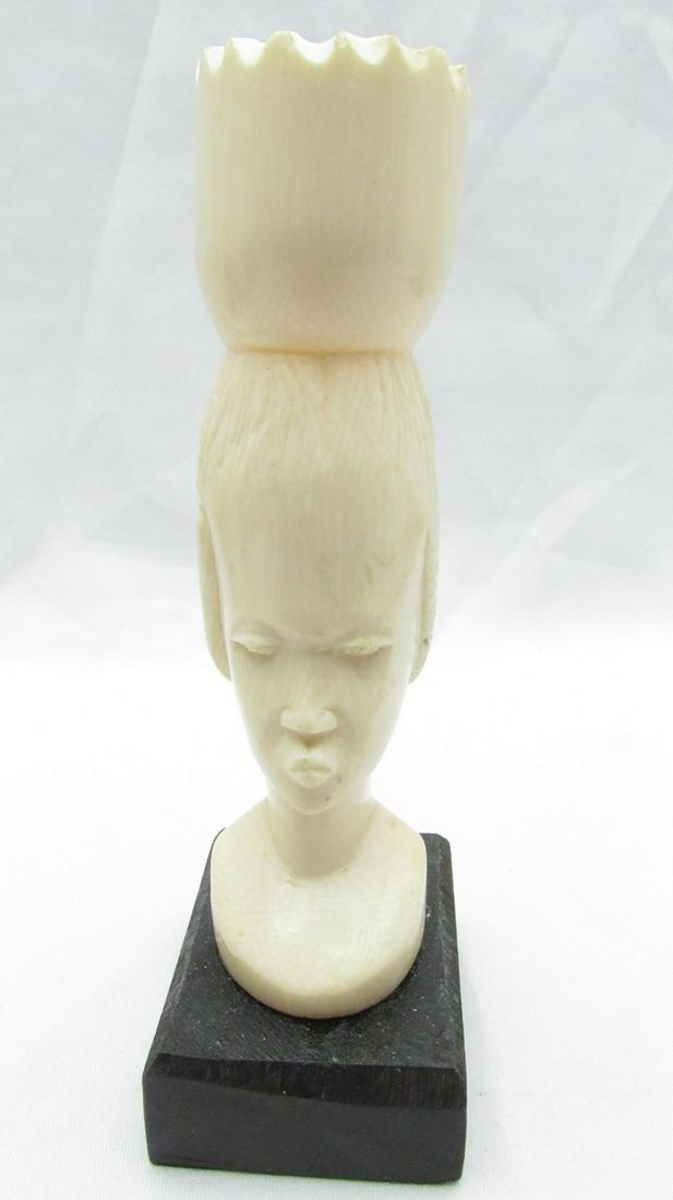 Old African carved woman's bust: Old African carved woman's bust, circa mid 20th century, "carrying a Jugendstil on her head", hand carved by an artisan from natural yellow organic material, and attached to a raised square black wood
