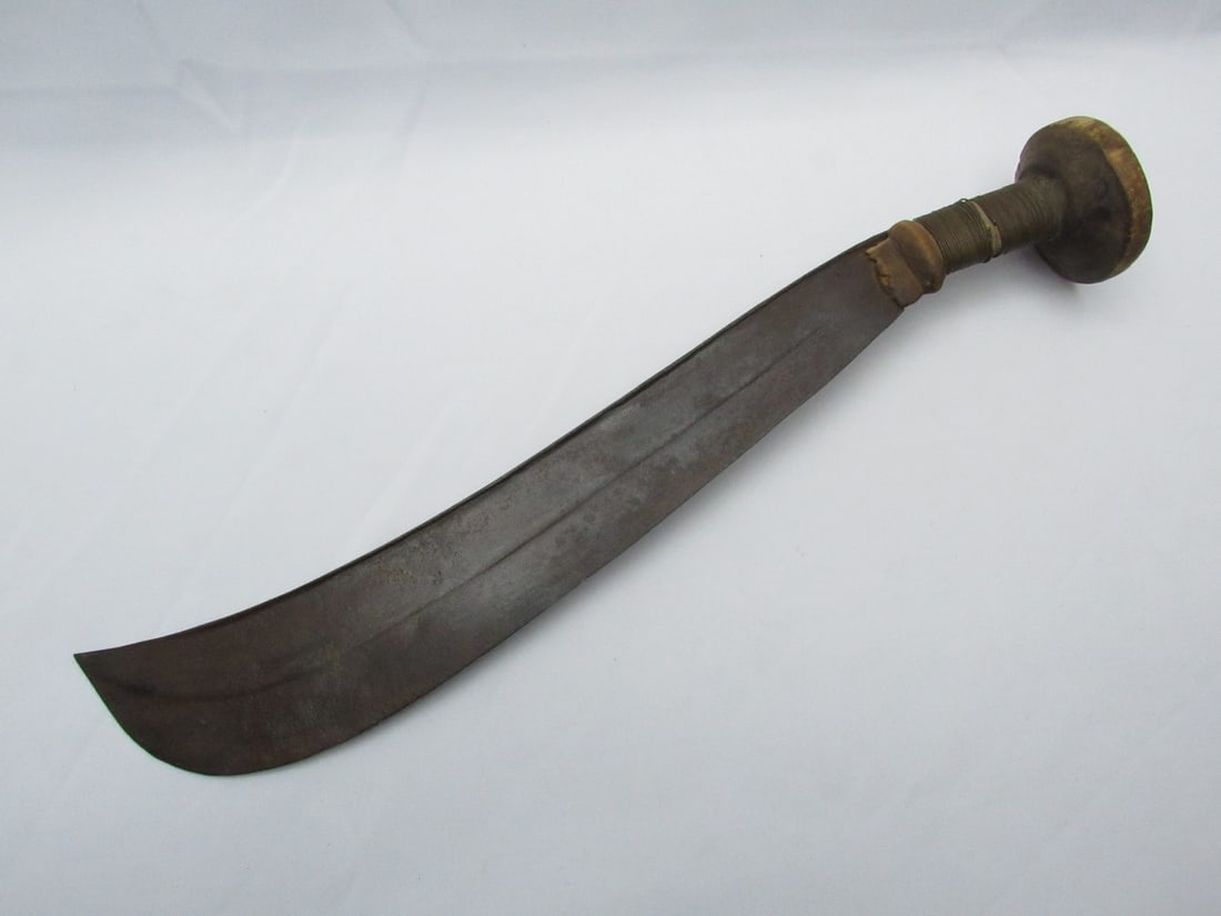 Old African curved sword: Old African curved sword, blade made of steel and wooden handle with copper wire decoration wrapped around the handle, length: 49 cm. Wear and age marks.