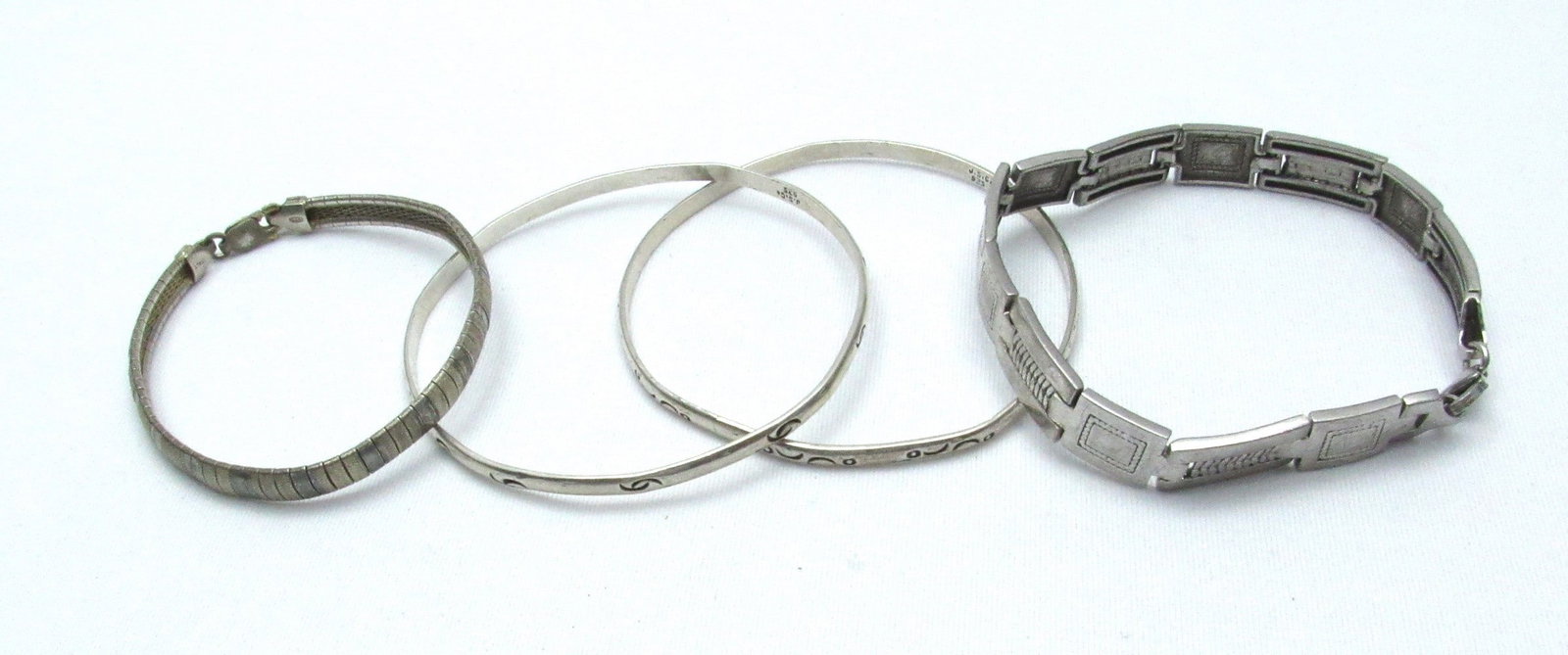 Assortment of 4 vintage 925 silver bracelets: Assortment of 4 vintage 925 silver bracelets, including 2 solid bangle bracelets and 2 link bracelets, signed, total weight: 49 g, diameter: 6-6.5 cm. Slight curvature to both solid bracelets.