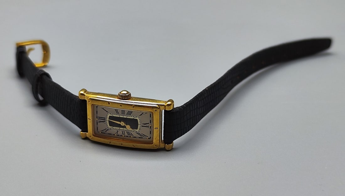 A high-quality luxury wristwatch for women made by Seiko: A high-quality luxury wristwatch for women made by Seiko, Switzerland, model 4N00-5509, gilded stainless steel case, black leather band with gilded clip, white enamel face decorated with Roman numeral