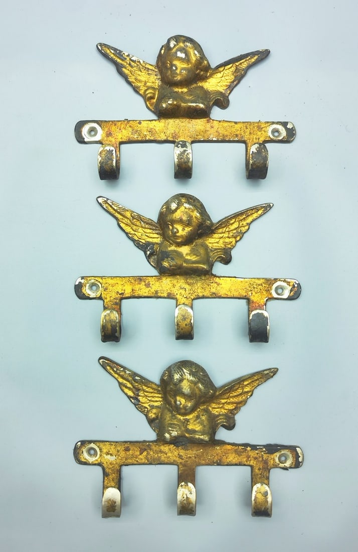 An assortment of 3 "angel" brass hangers: An assortment of 3 "angel" brass hangers, old quality castings, gilded patina, each with 3 hooks, width: 15 cm. Abrasions and patina.