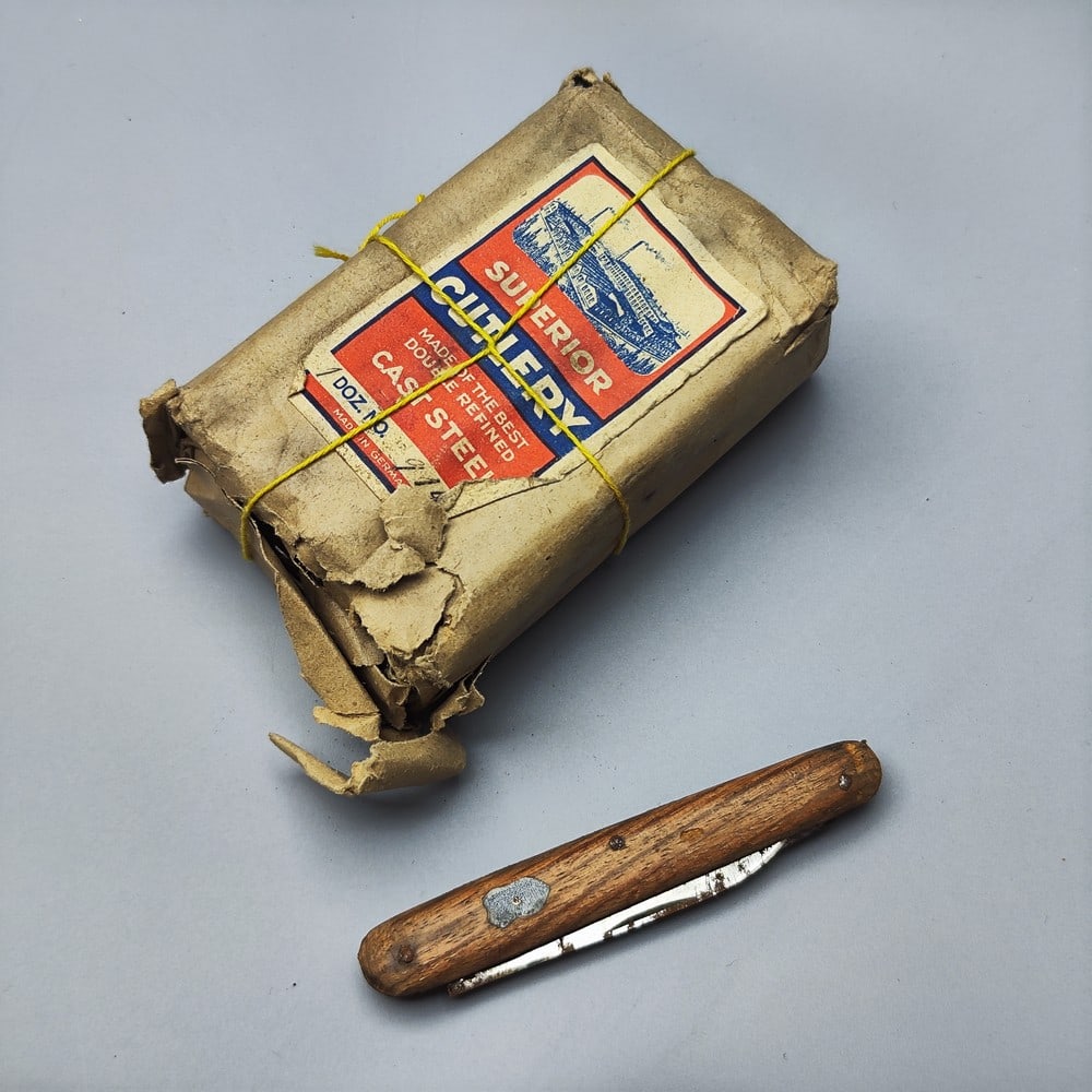 Special! From the evacuation of a warehouse that has not been opened since the mandate period!: Special! From the evacuation of a warehouse that has not been opened since the mandate period! A closed cardboard box of identical pocketknives, circa 1940s, covered with a light wooden cover with shi