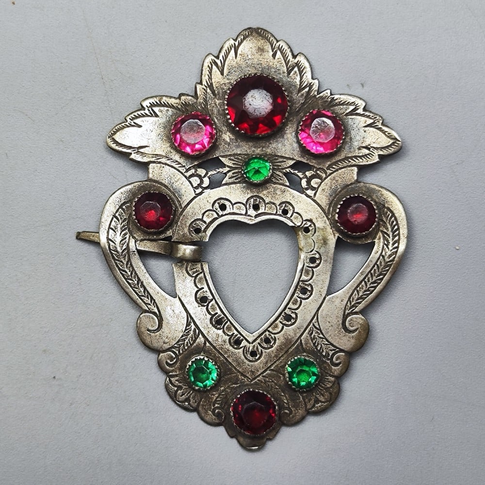 Antique European silver belt buckle: Antique European silver belt buckle, 19th century, designed with a shield pattern and decorated with engravings with a vegetation pattern and ruby ??and faux-emerald glass beads polished in round cuts