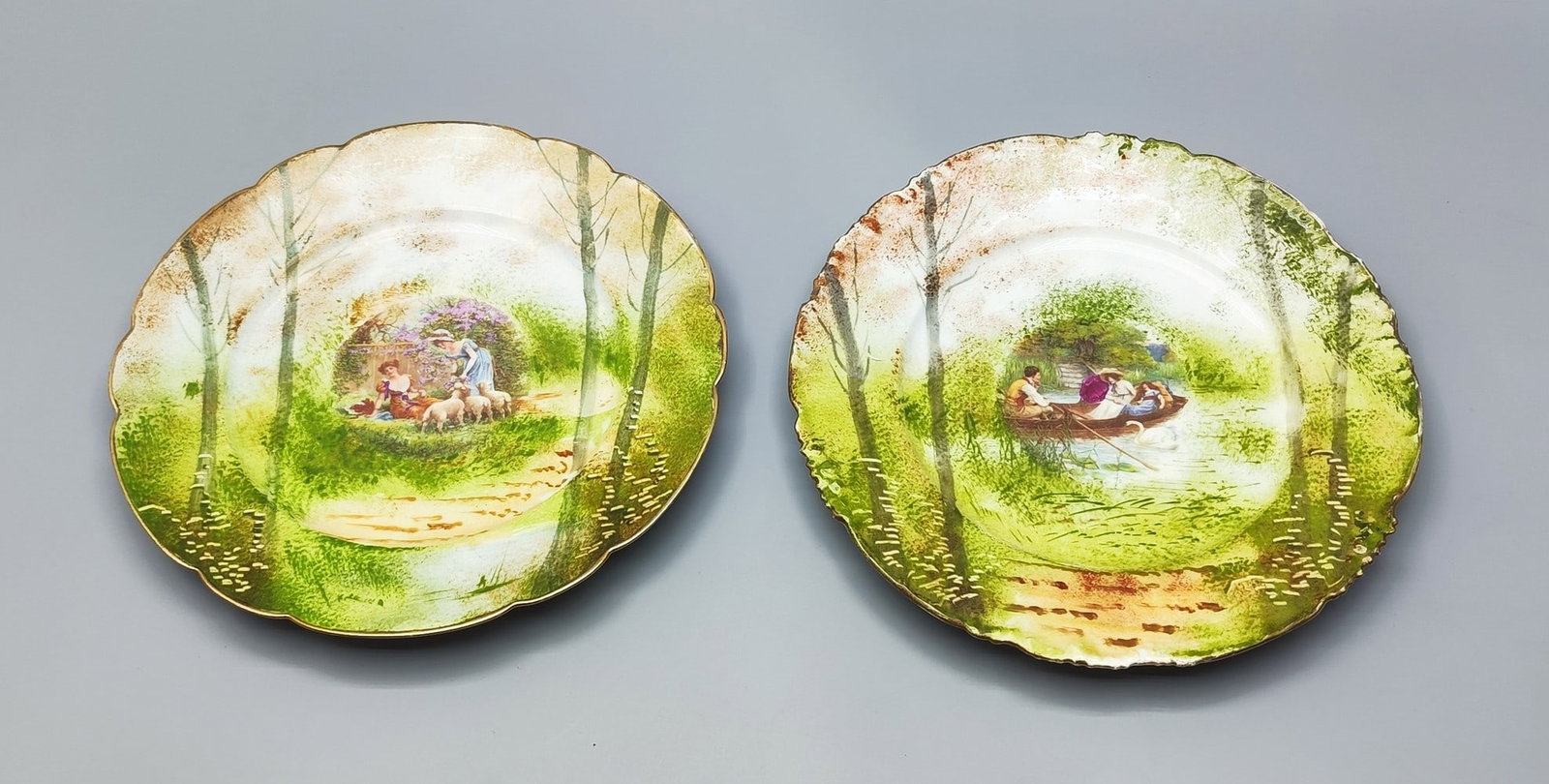 A pair of antique hand painted porcelain plates made by J.P. Limoges: A pair of antique hand painted porcelain plates made by J.P. Limoges, circa late 19th century, decorated with high-quality hand painting, one showing a boat ride in a river against the background of t