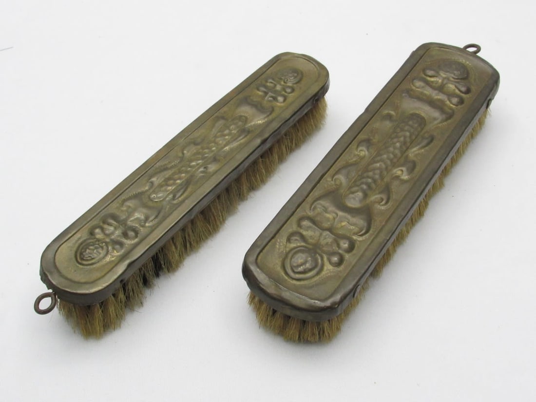 A pair of Art Nouveau cleaning brushes: A pair of Art Nouveau cleaning brushes, circa 1900, made of gilded metal, decorated with handcrafted embroidery in a plant pattern in the style of the period, length: 18.5-19.5 cm. Light wear, patina.